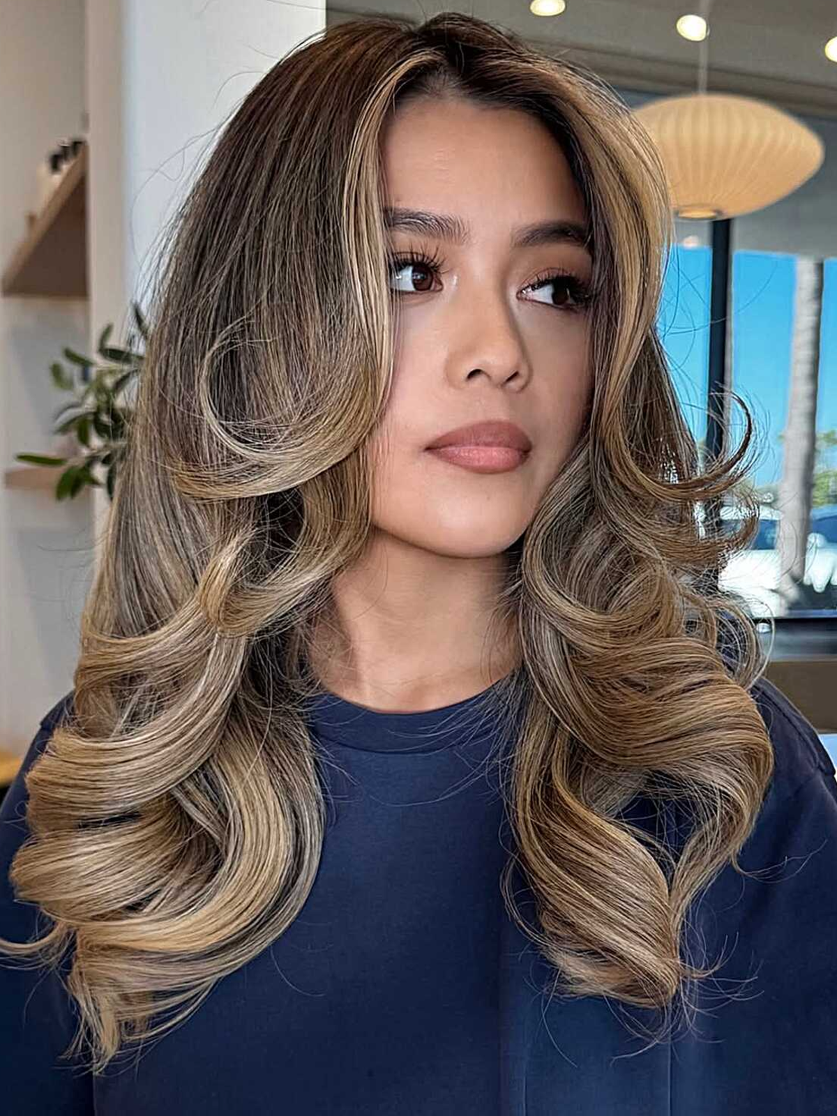 Long bronde hair with bouncy blowout layers and bright highlights.