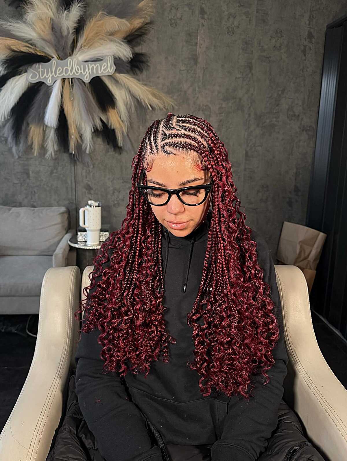 Burgundy braids with curved front parting and loose curly lengths.