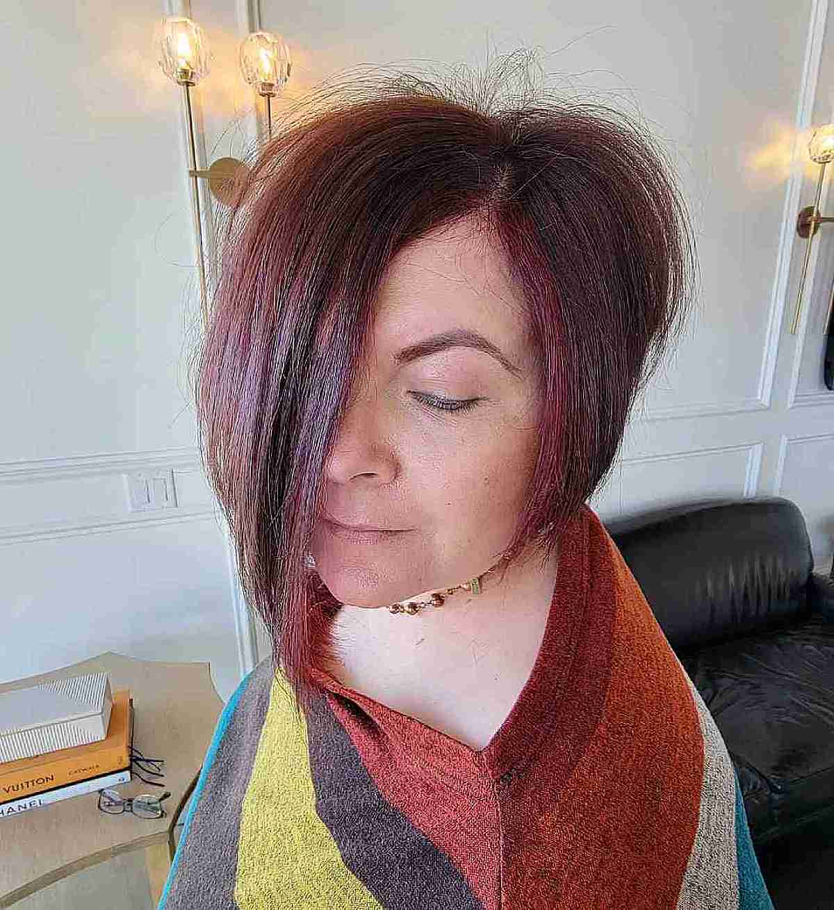 Side-parted dark red angled bob with a sharp front angle.