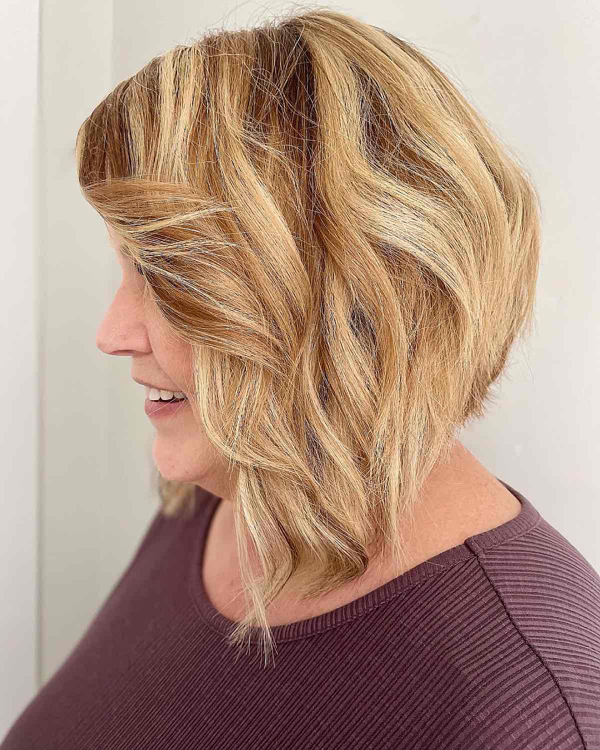 Blonde angled bob with side-swept fringe and layered movement.