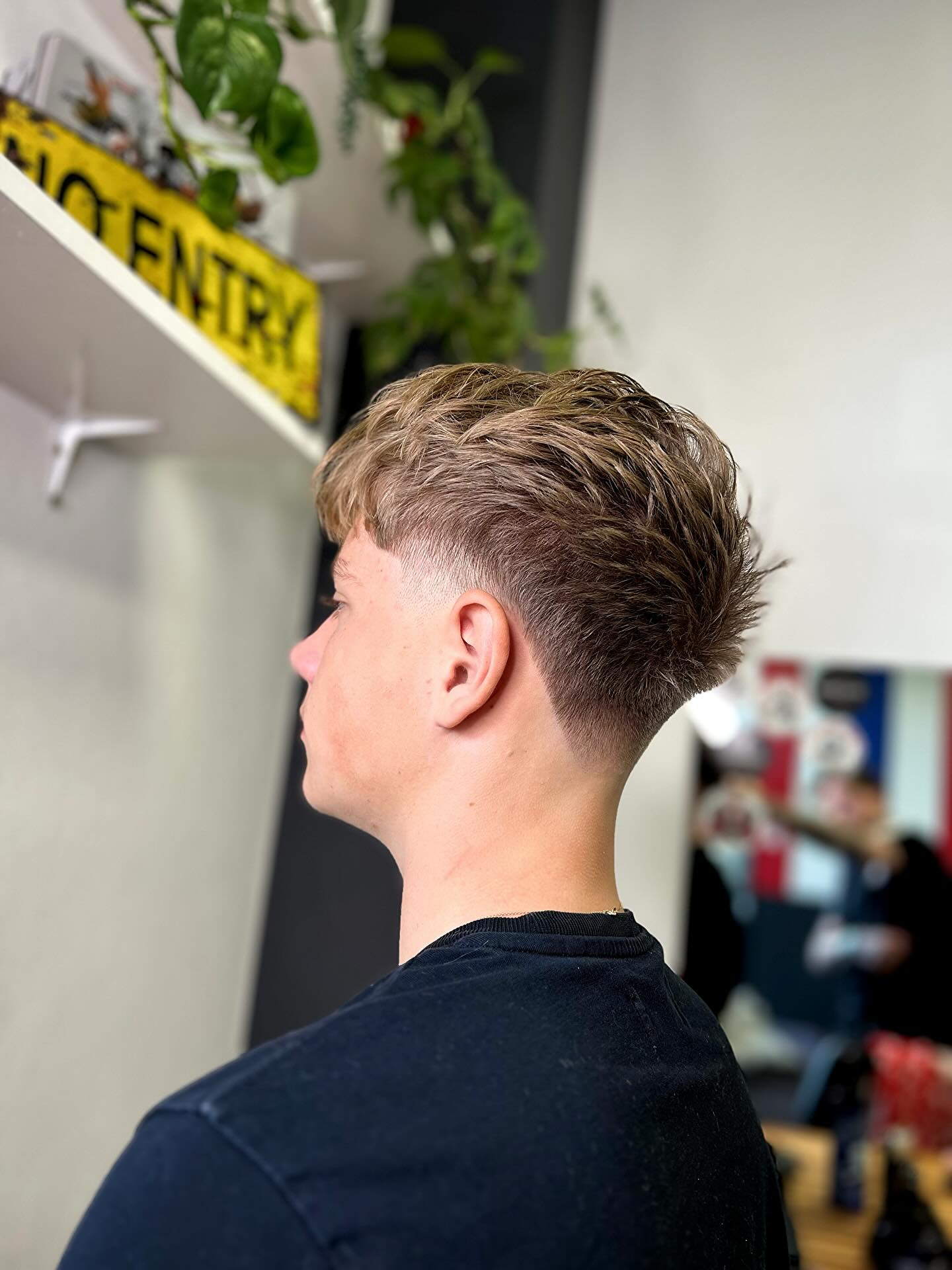 Lightly layered top with low taper fade and neat sides.