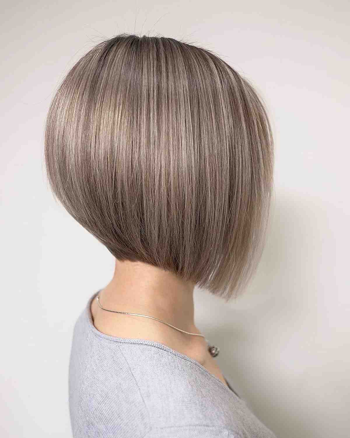 Sleek beige blonde angled bob with a narrow front point.
