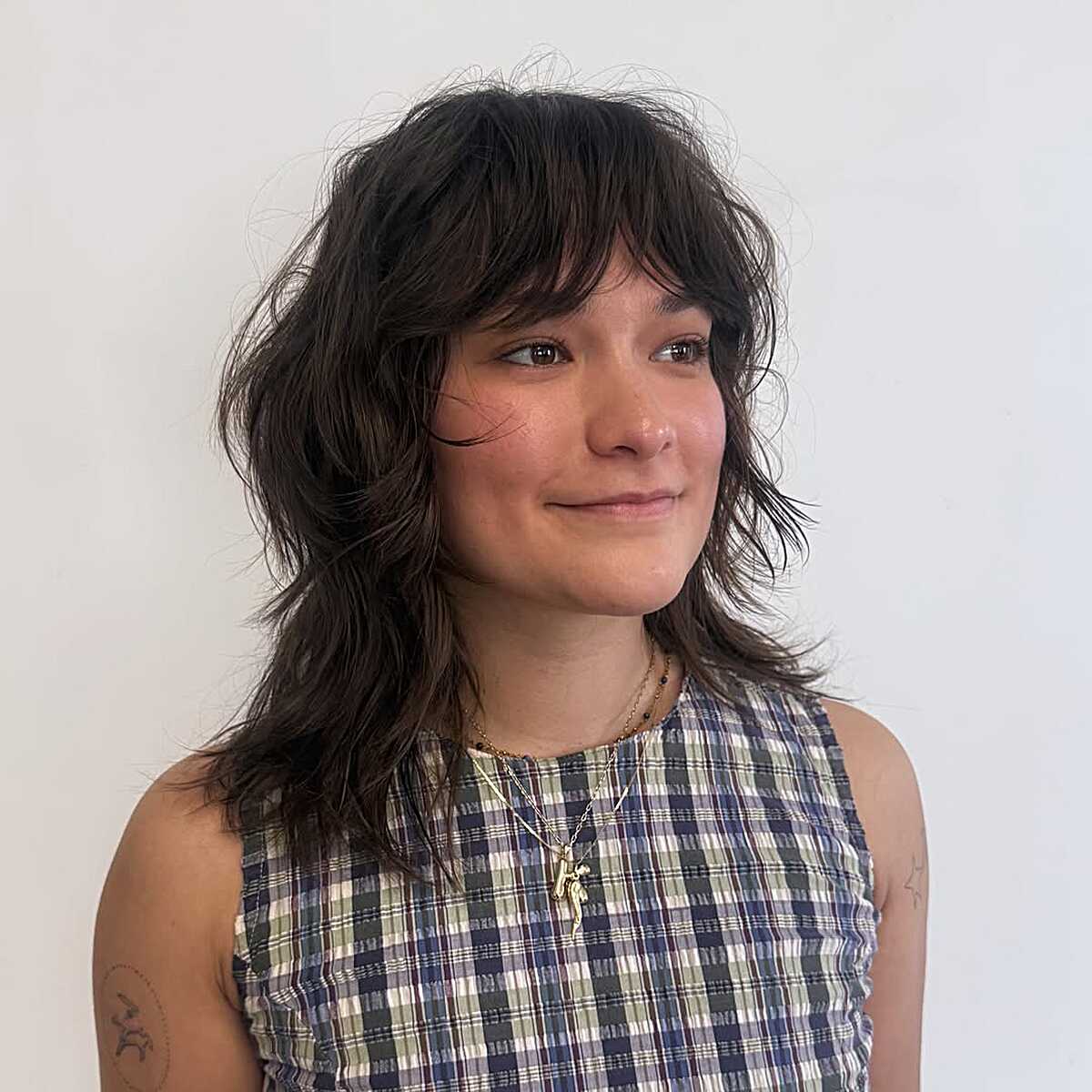 Dark brunette tousled shag with piecey bangs and soft layers.