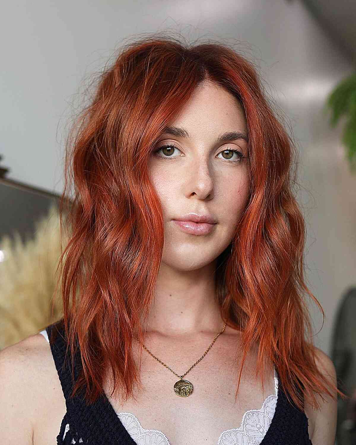 Copper-red layered hair below the shoulders with loose waves.