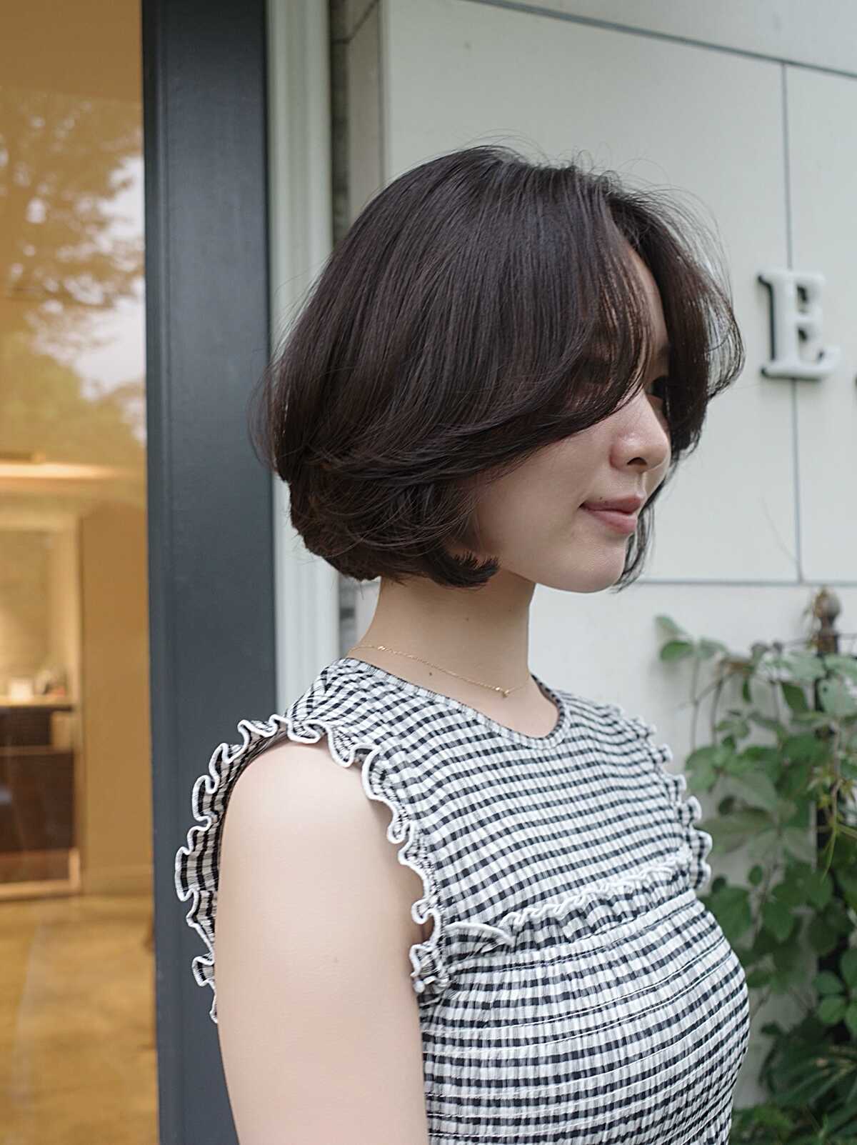 Dark brown chin-length bob with side-swept layers and flipped ends