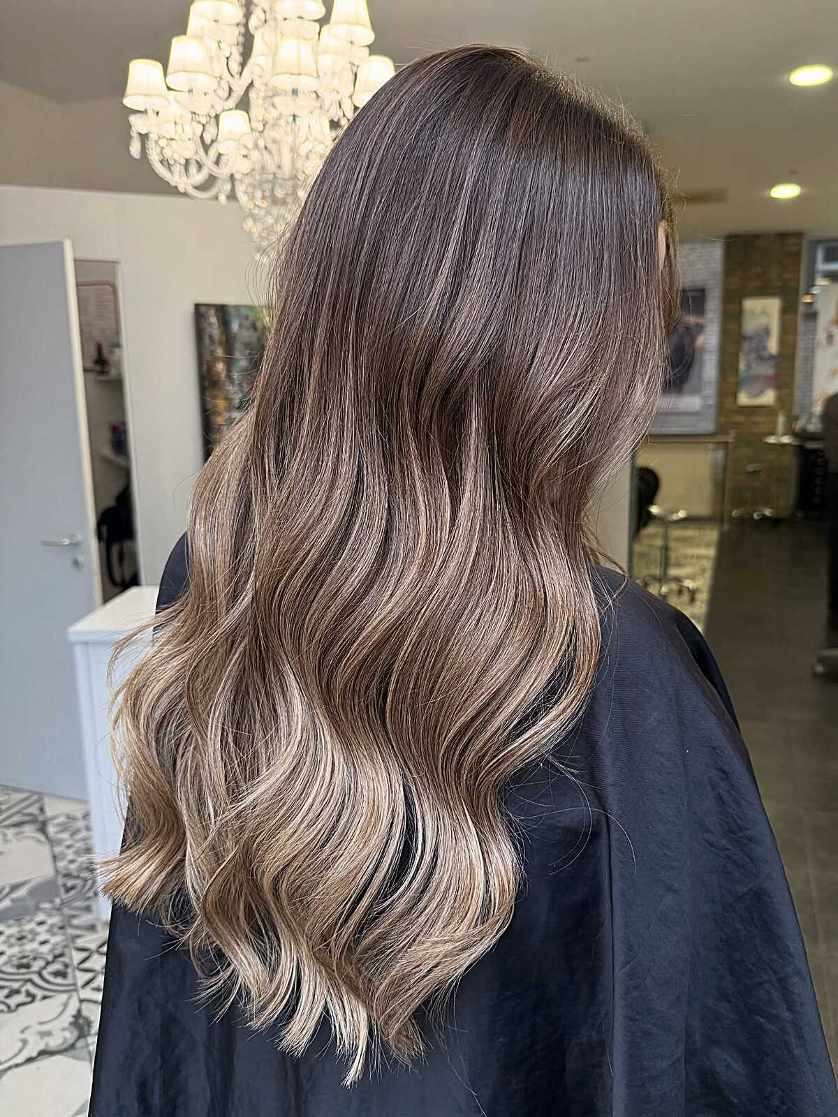 Long thick bronde hair with cool ash tones and soft waves.