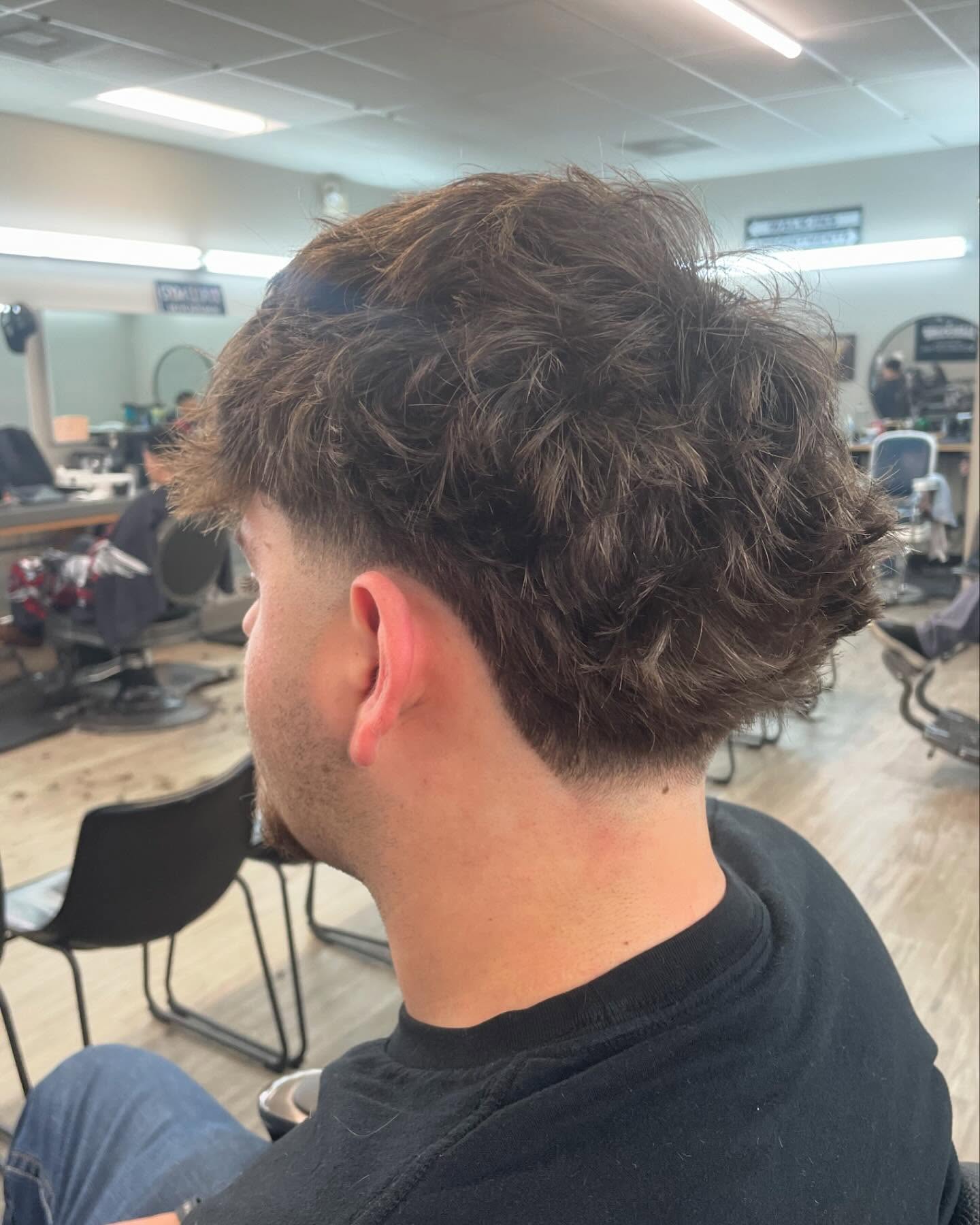 Loose curly top with tapered sides and rounded back.