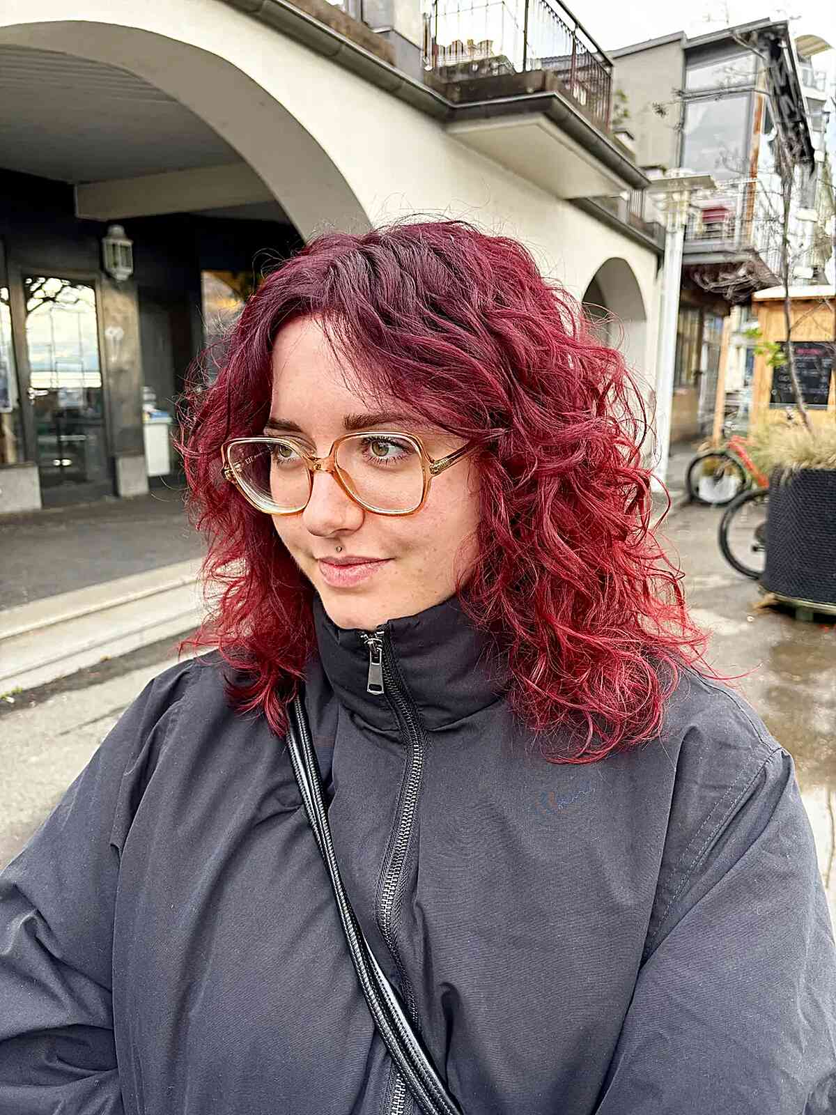 Short red wavy haircut with shaggy layers and fringe.