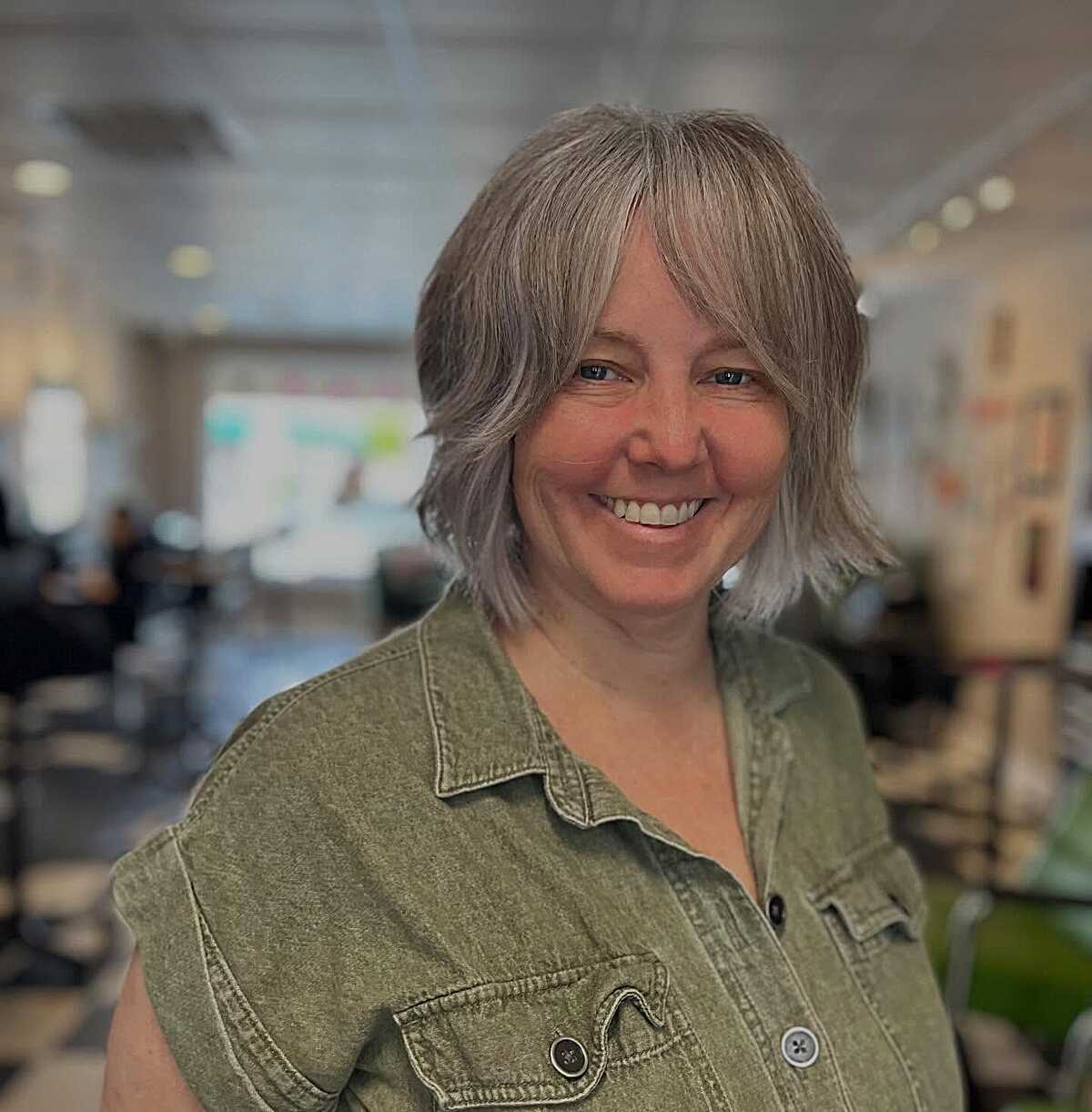 Layered silver bob with side-swept bangs and feathered ends