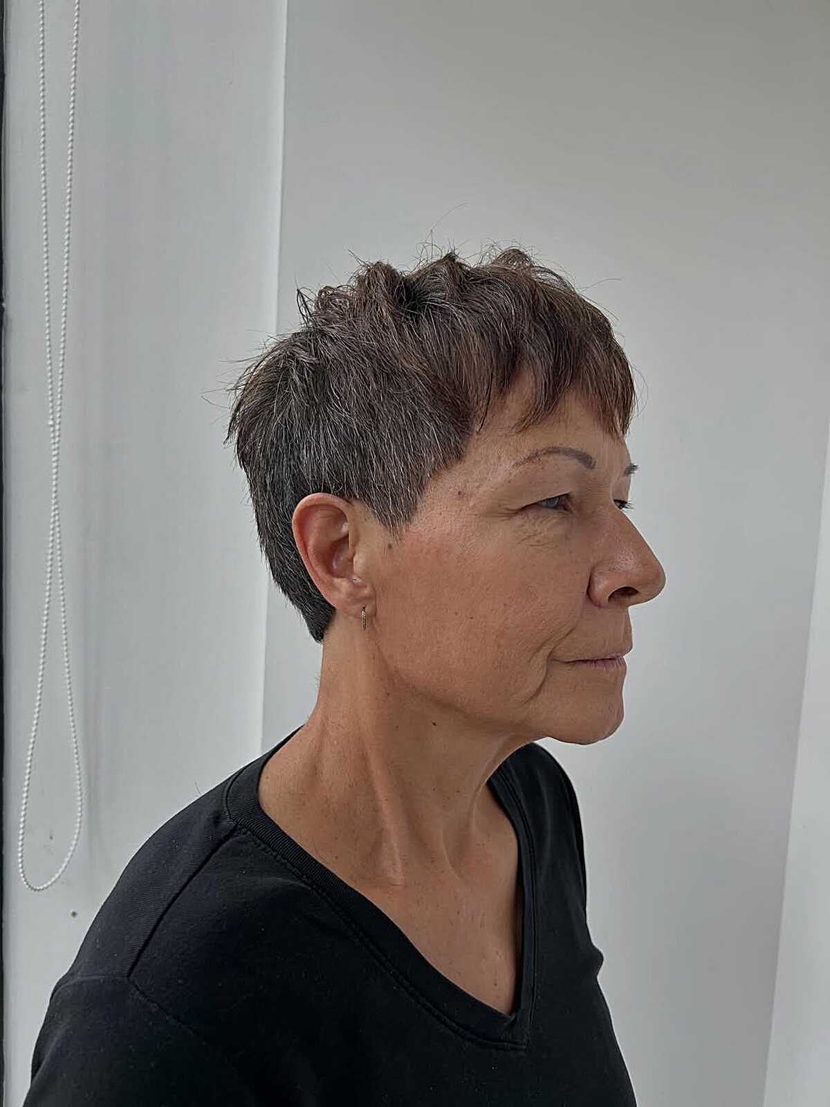 Dark textured pixie with choppy top and tight ear taper.