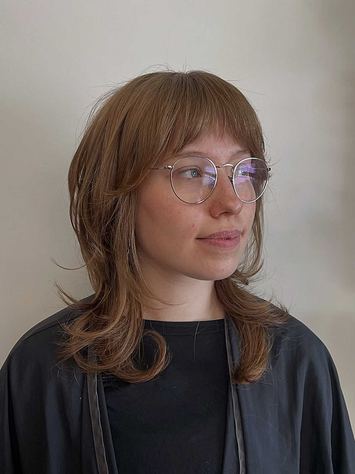 Strawberry blonde shag with bottleneck bangs and shoulder-grazing layers.