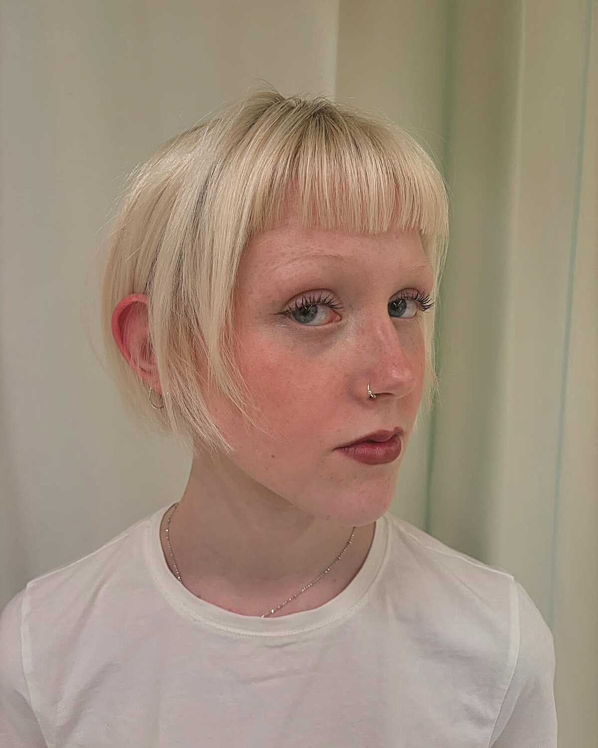 Platinum blonde ear-length bob with straight bangs and short side pieces