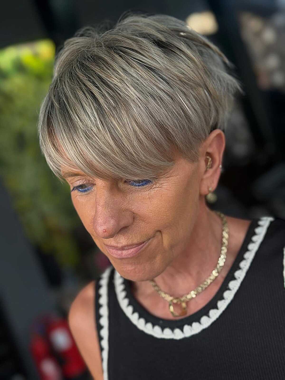 Ash blonde pixie with full fringe and layered crown.