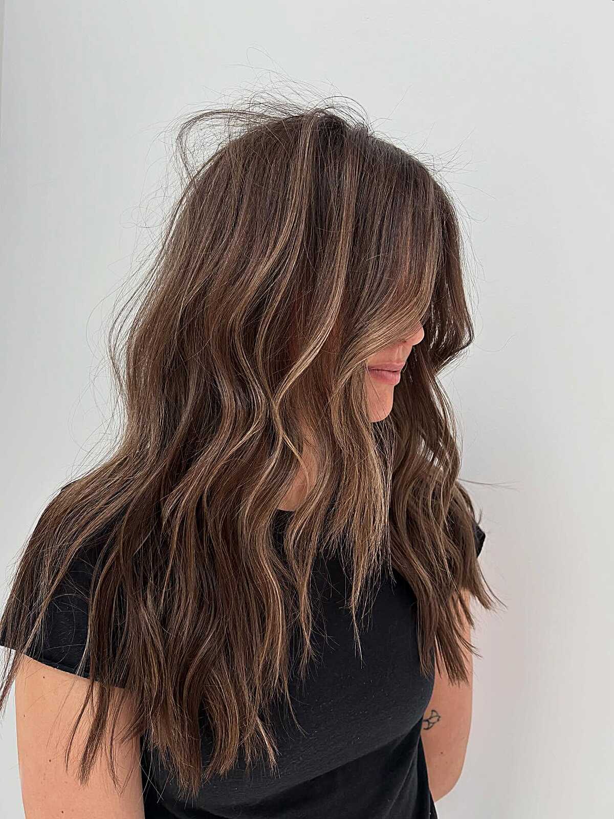 Medium brunette waves with scattered blonde highlights.