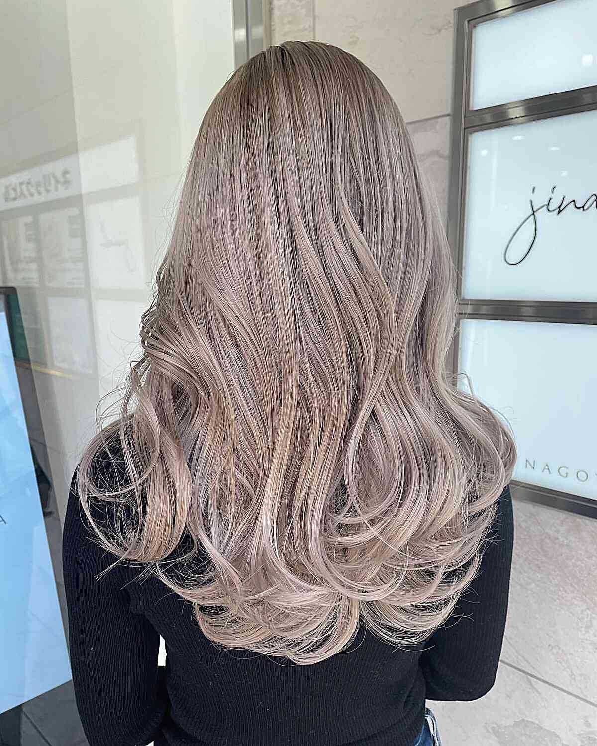 Ash beige blonde long layers seen from the back.