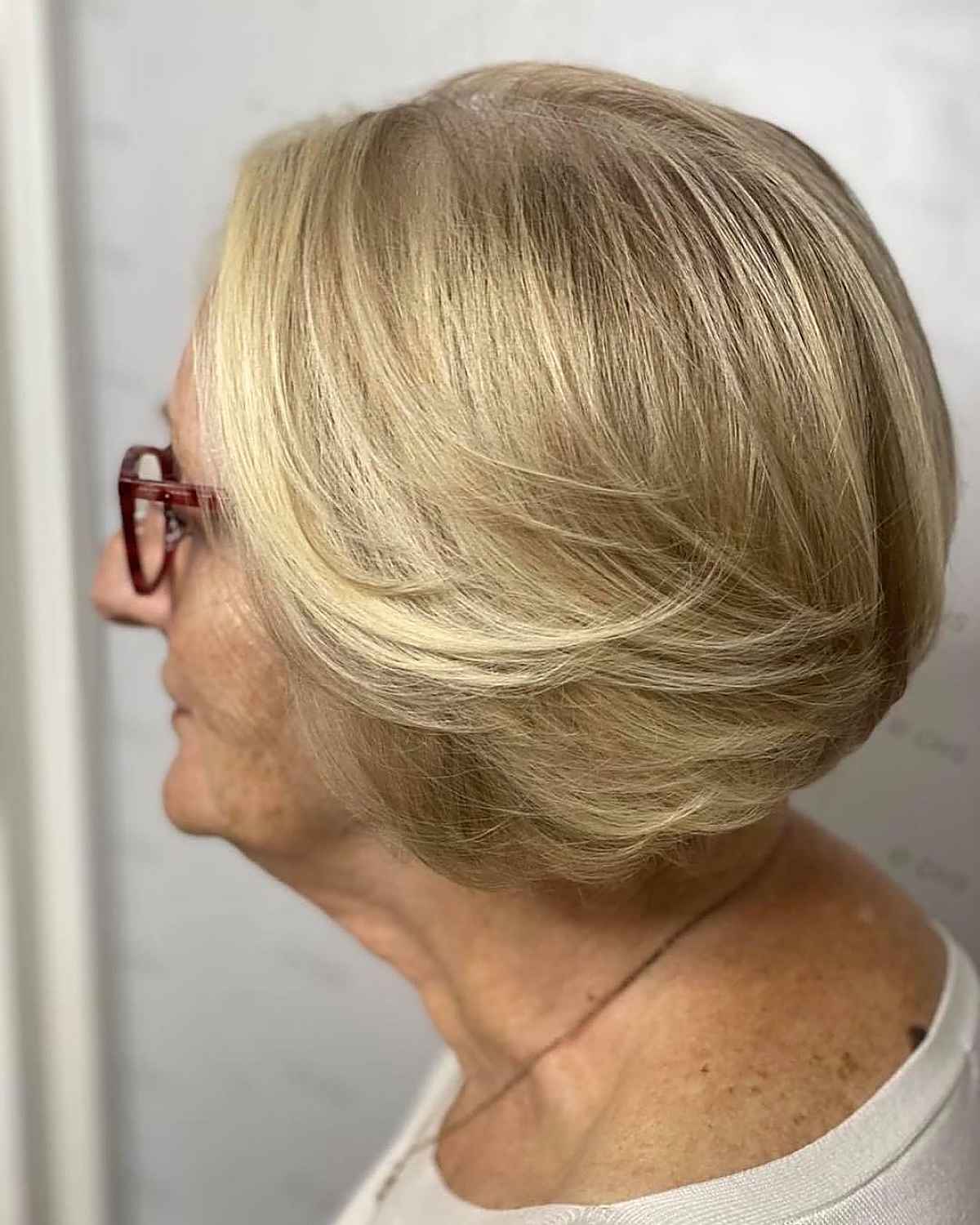 Feathered blonde bob with a rounded back and smooth top.