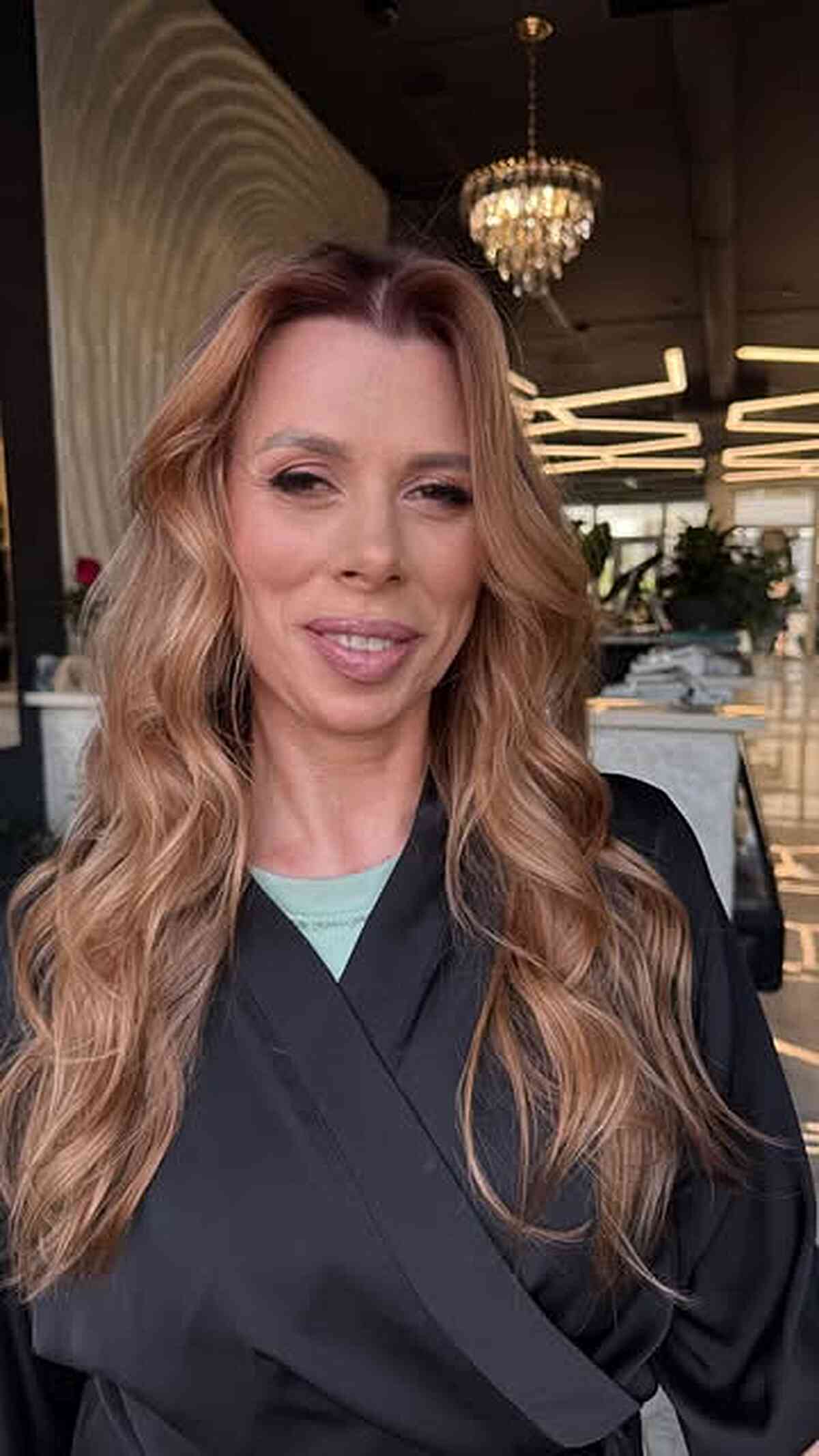 Long warm beige blonde waves with a soft side part.