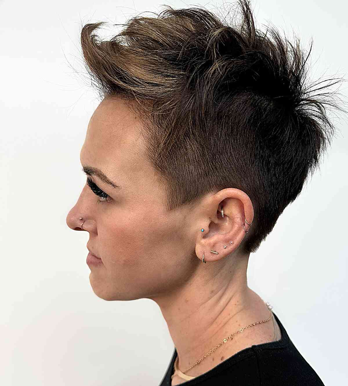 Brunette pixie with swept-up top and tapered sides.