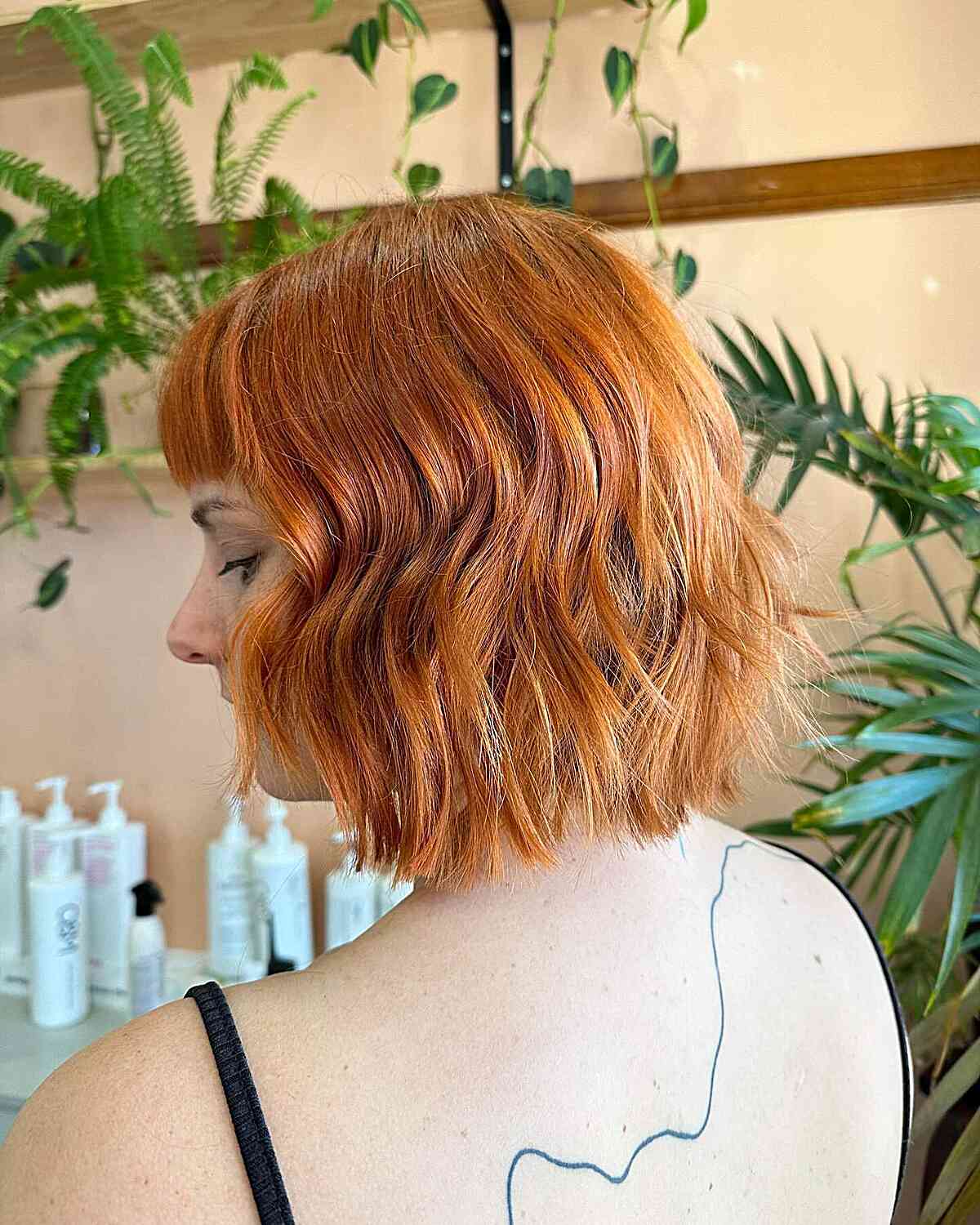 Neck-length copper bob with soft waves and textured ends.