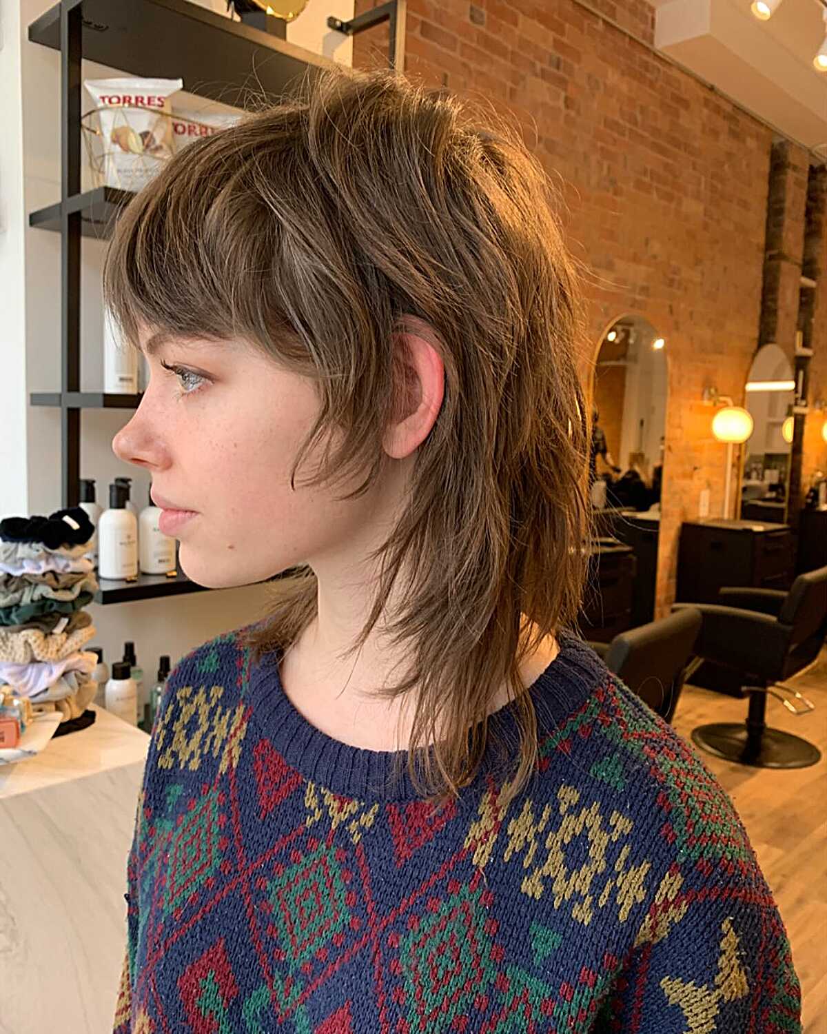 Brunette mullet-inspired shag with micro bangs and longer nape.