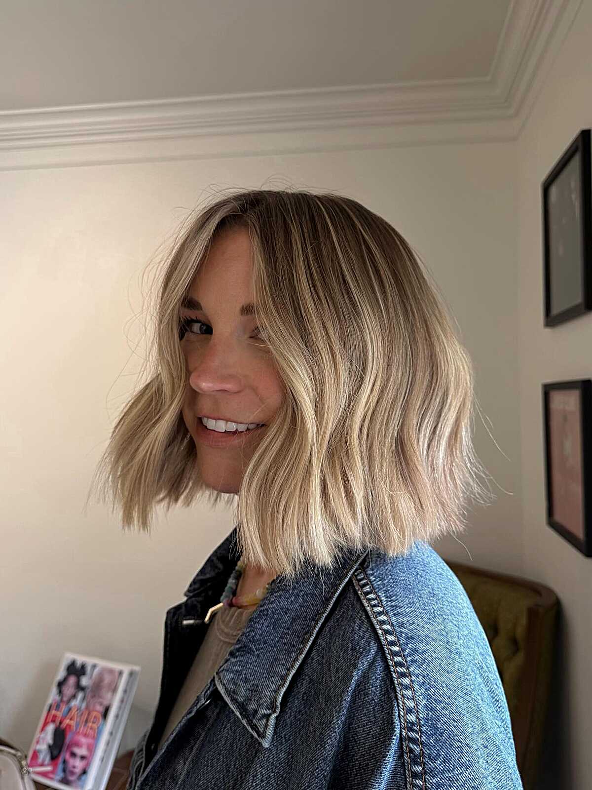 Blonde balayage bob with loose waves and a softly off-center part