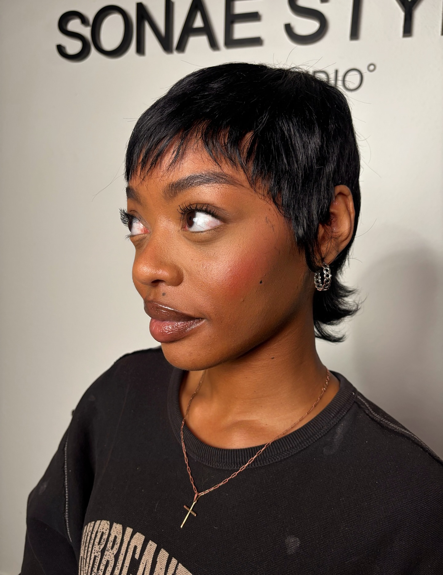 Short black pixie with feathered nape and short fringe.