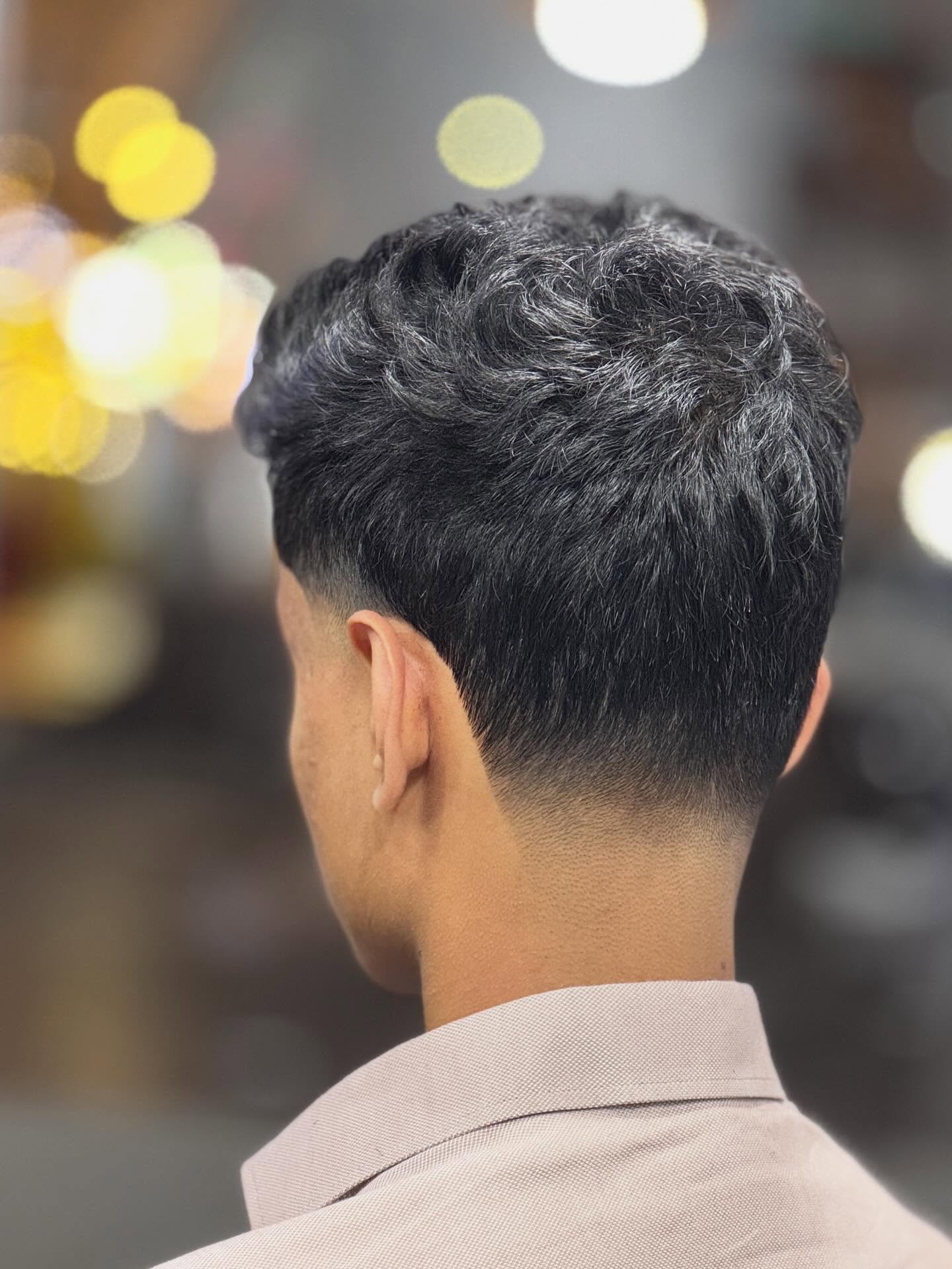 Curly top with clean taper on the sides and nape.
