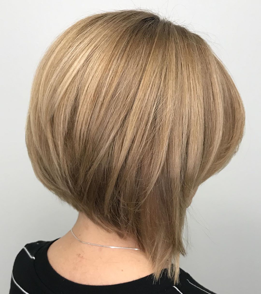 Back view of a blonde angled bob with a stacked rounded shape.