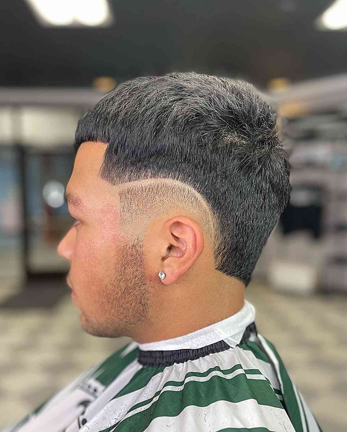 Short textured crop with a burst fade and curved shaved line.