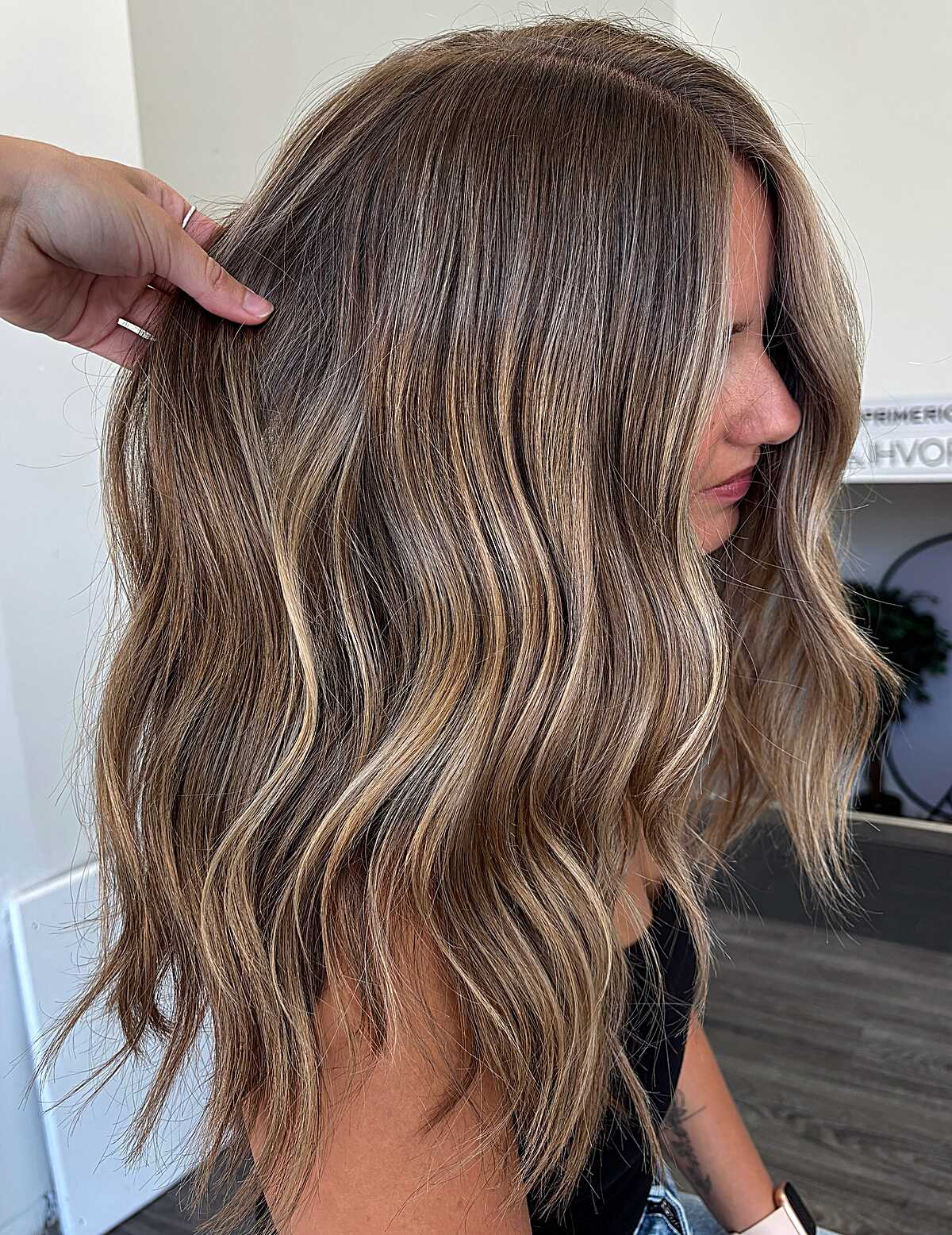 Medium wavy ash brown hair with sandy lowlight depth.