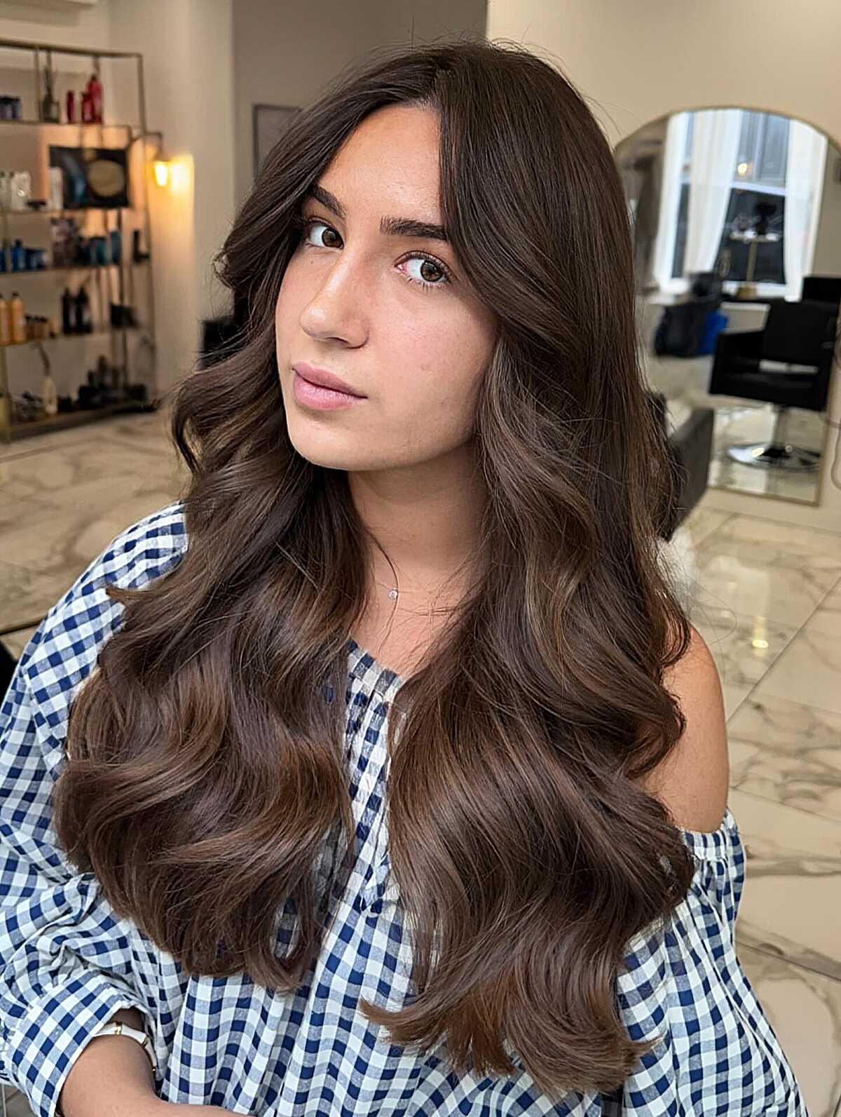 Long chocolate brown waves with a side part and rounded ends.