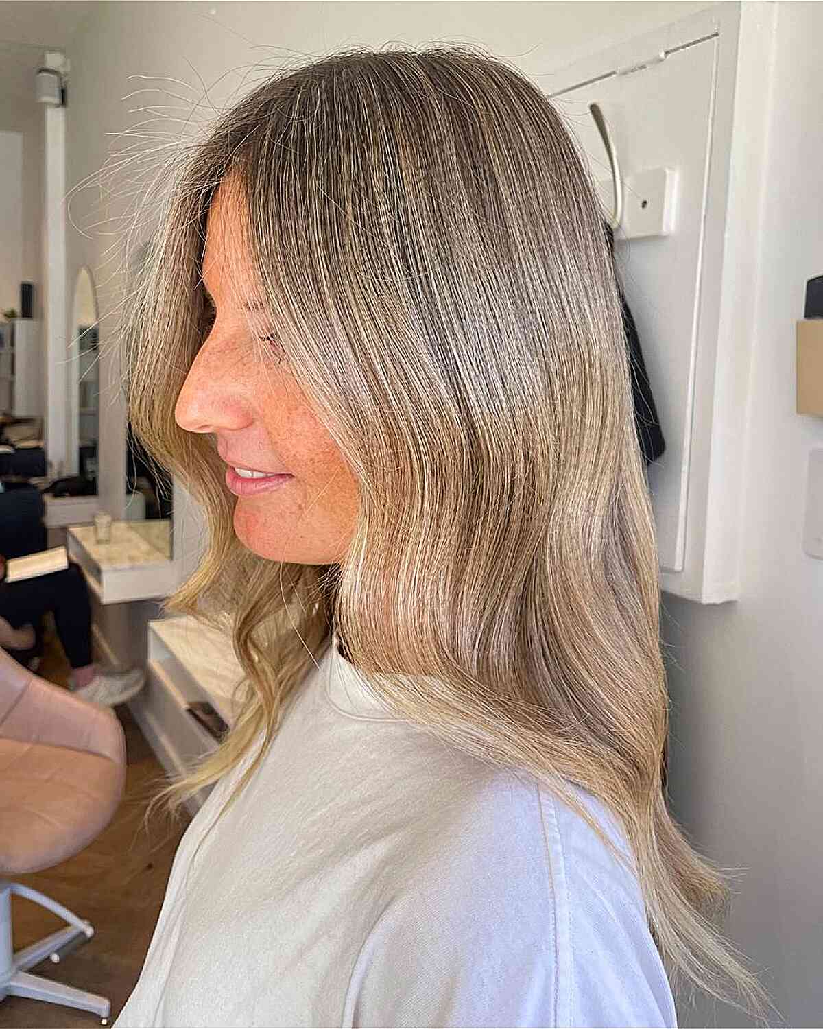Beige blonde waves with face-framing layers and soft ends.