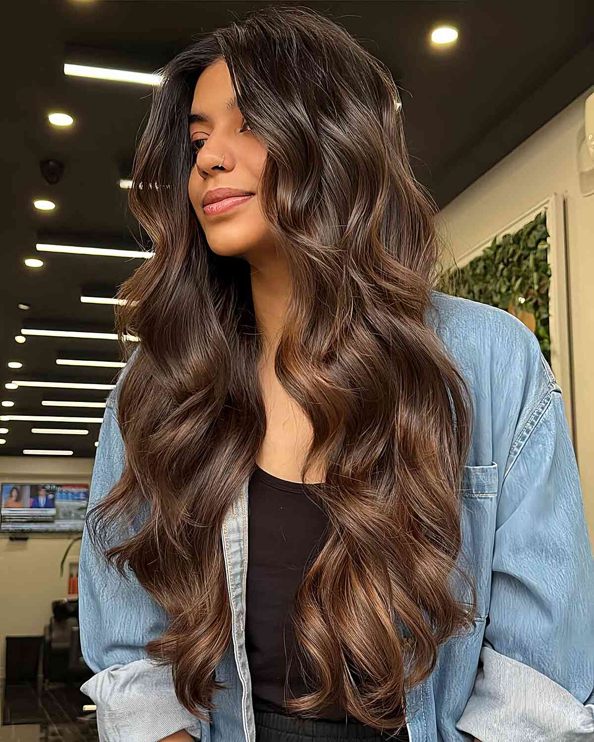 Extra-long dark brown hair with soft waves and warm highlights.