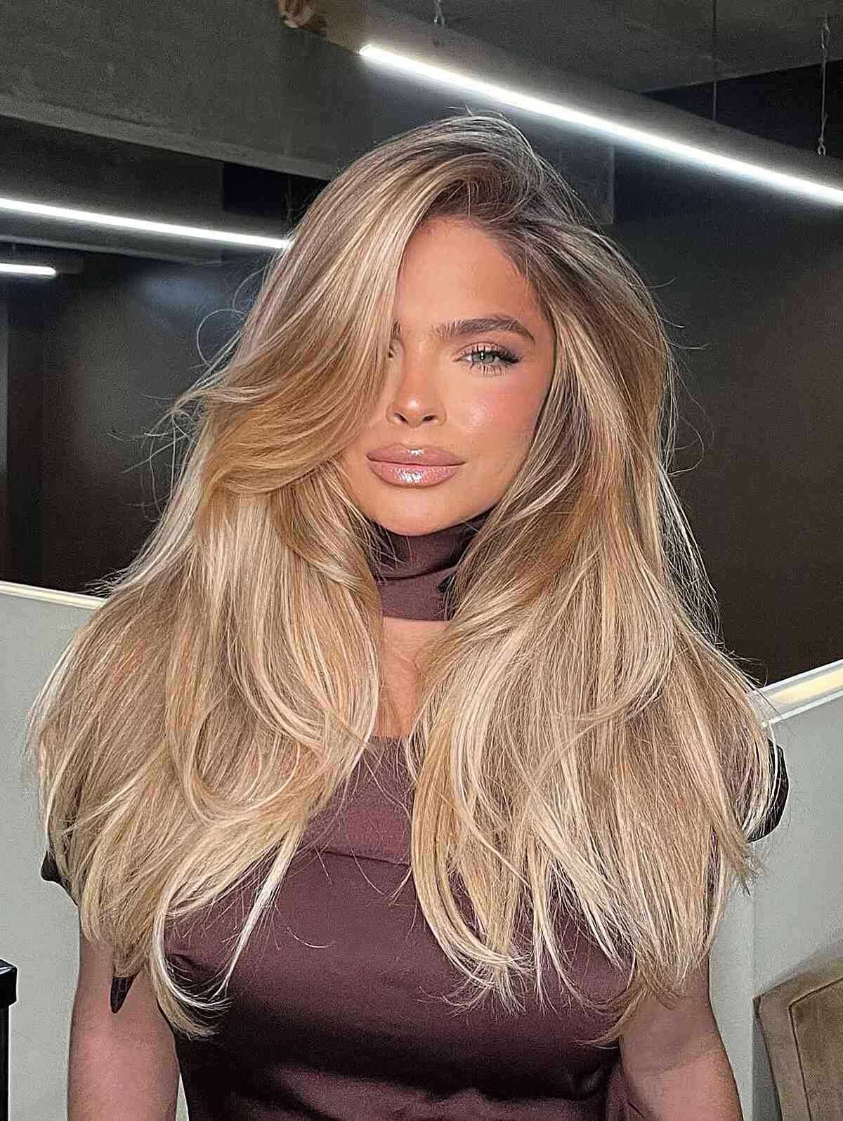 Golden beige blonde waves with a full, voluminous finish.