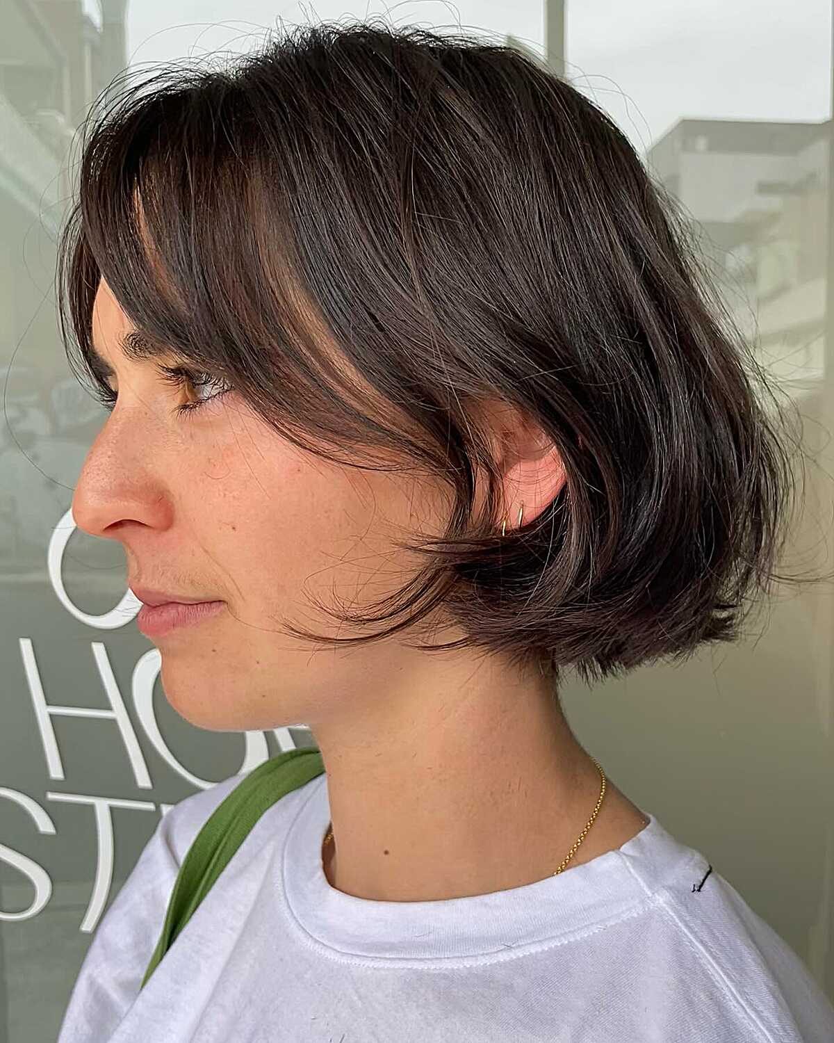 Chin-length dark bob with wispy fringe and softly layered ends.
