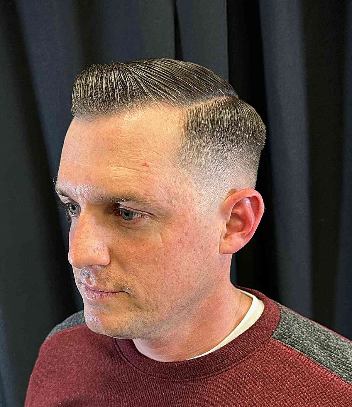 Side-parted short top with a zero fade and clean part line.