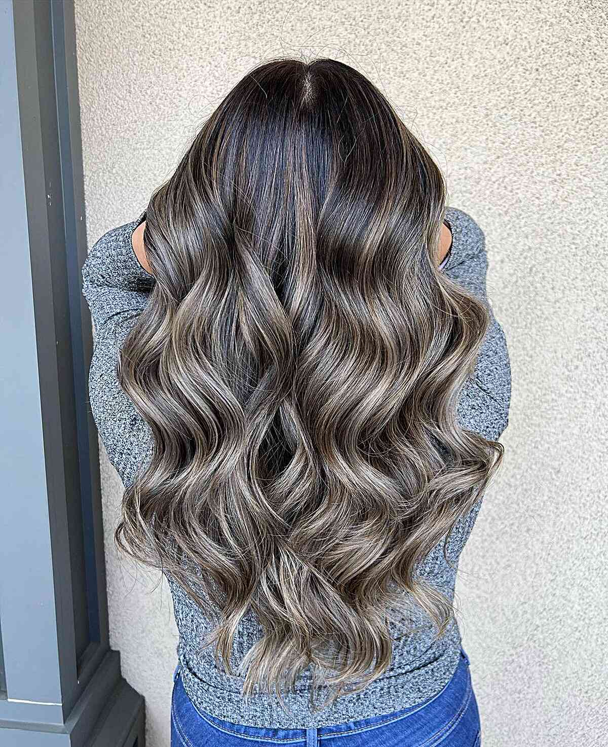 Waist-length ash bronde waves with dark roots and cool ribbons.