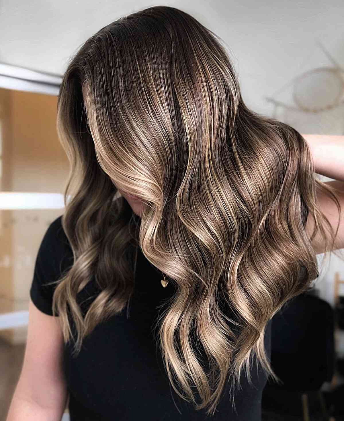 Long bronzed bronde waves with beige-gold highlights.