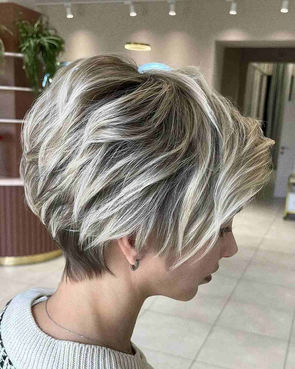 Platinum pixie bob with dark roots and layered crown.