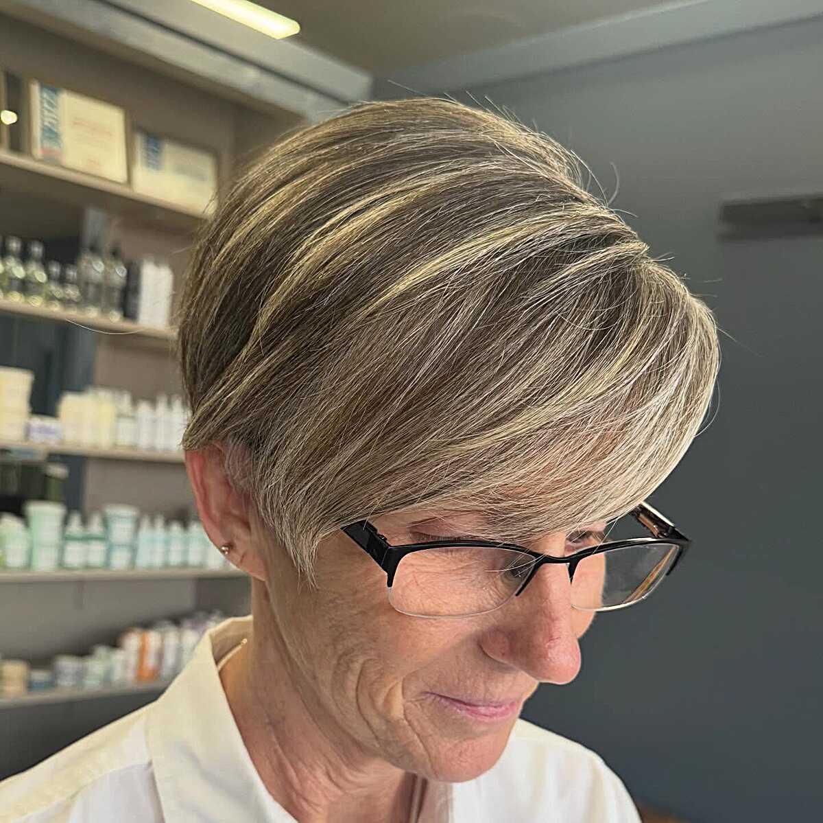 Blonde pixie with long side-swept top and tapered back.