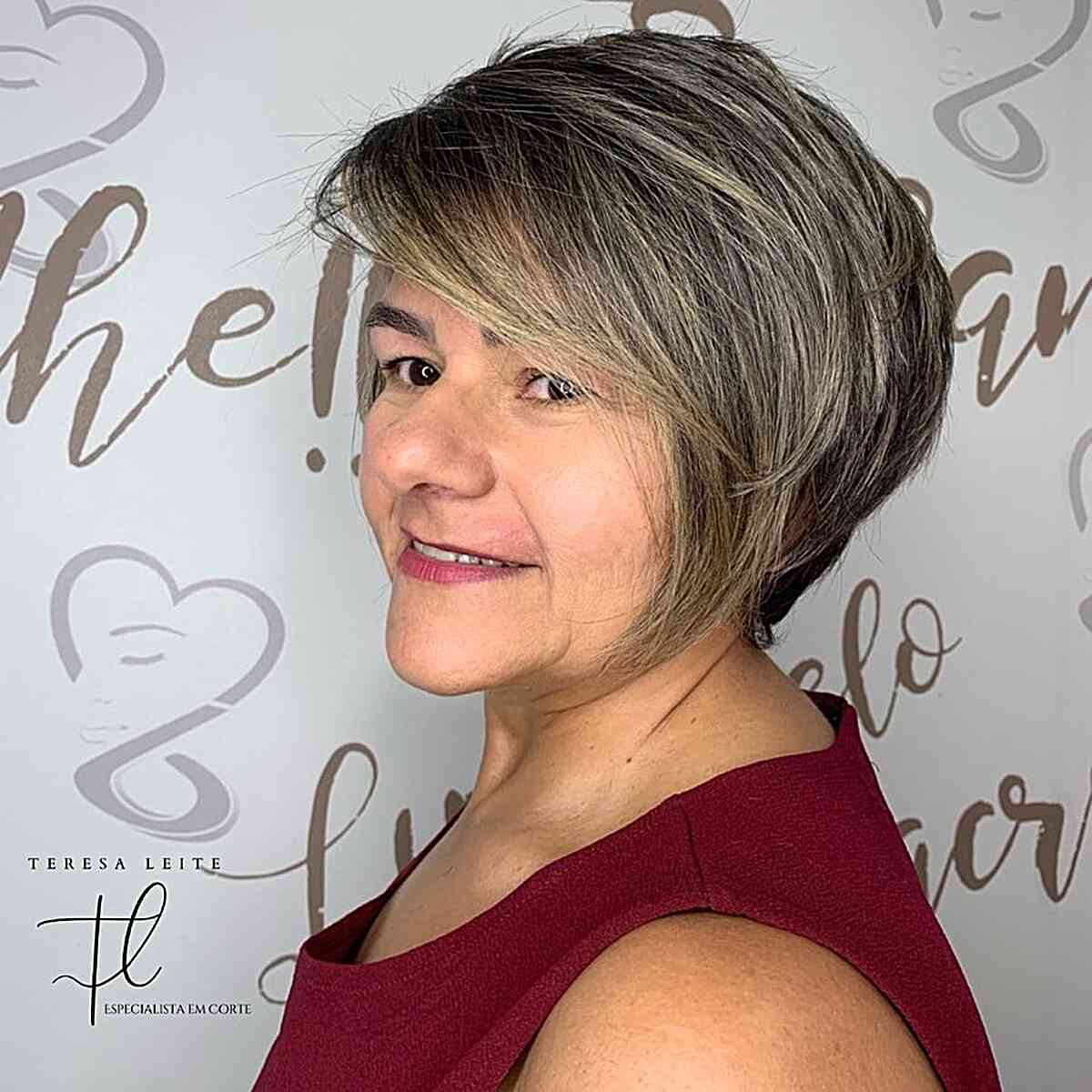 Graduated pixie bob with side-swept bangs and ash-blonde dimension.