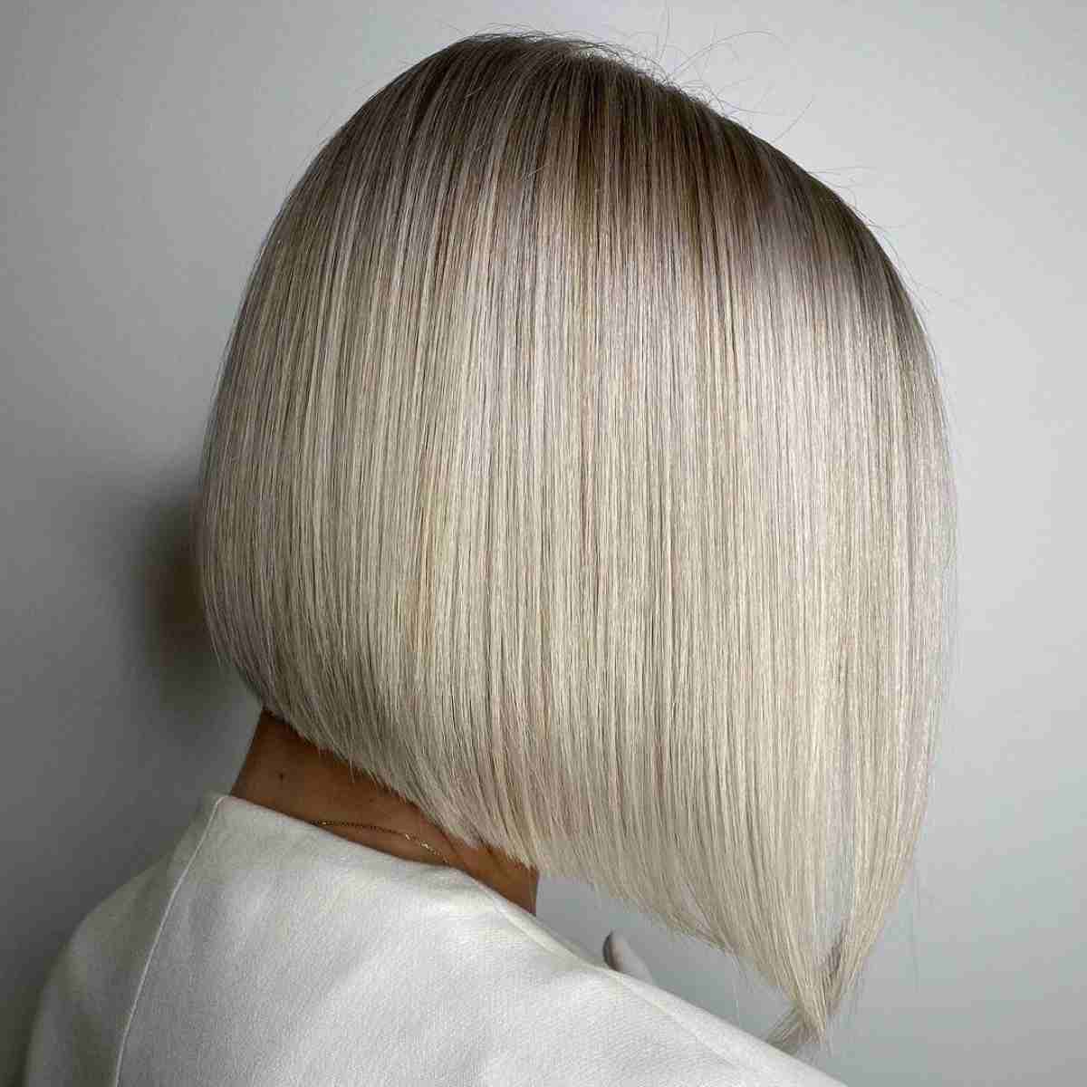 Glossy blonde angled bob with a tapered front and rounded back.