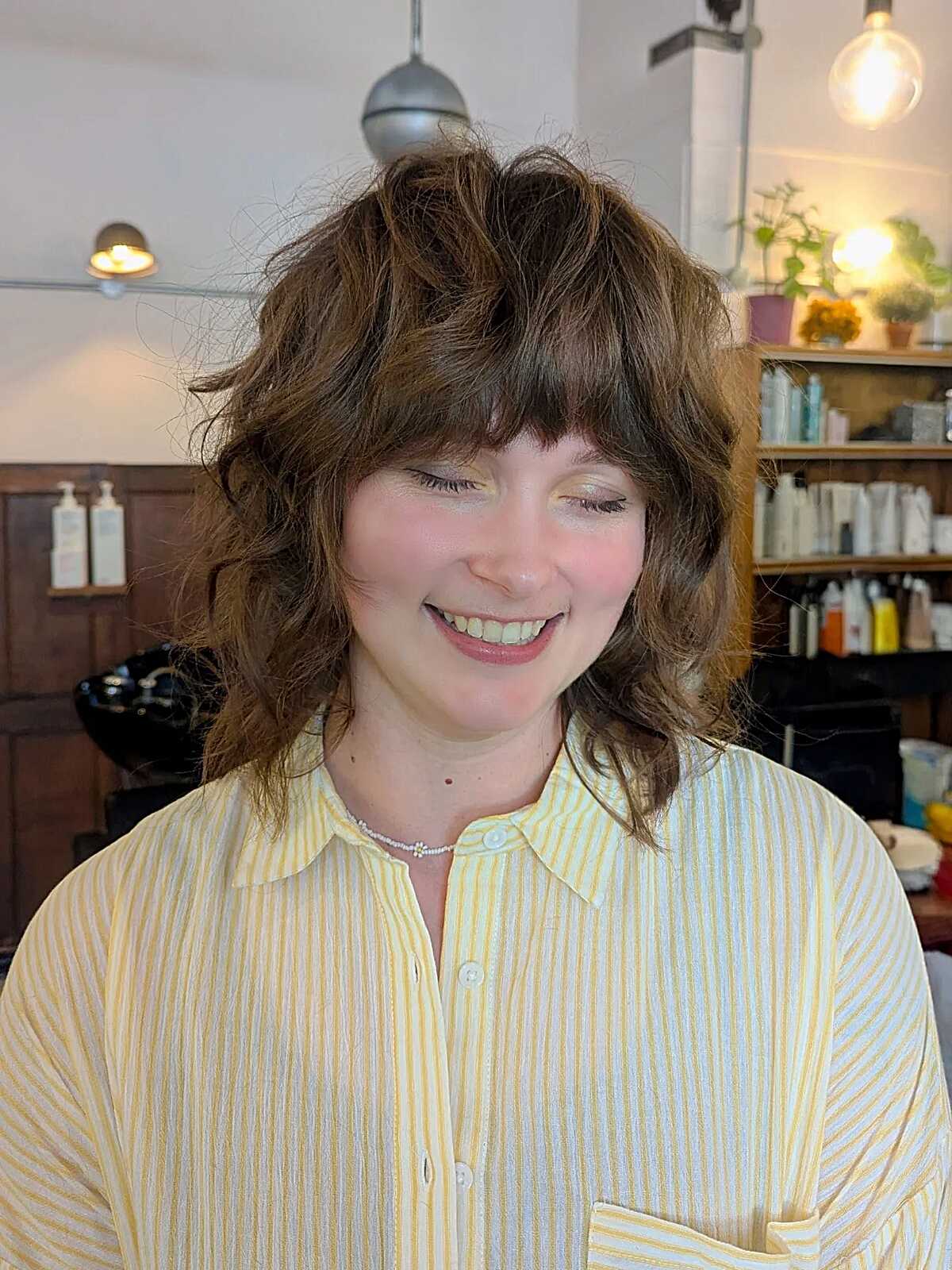 Curly brunette shag with rounded shape and full fringe.