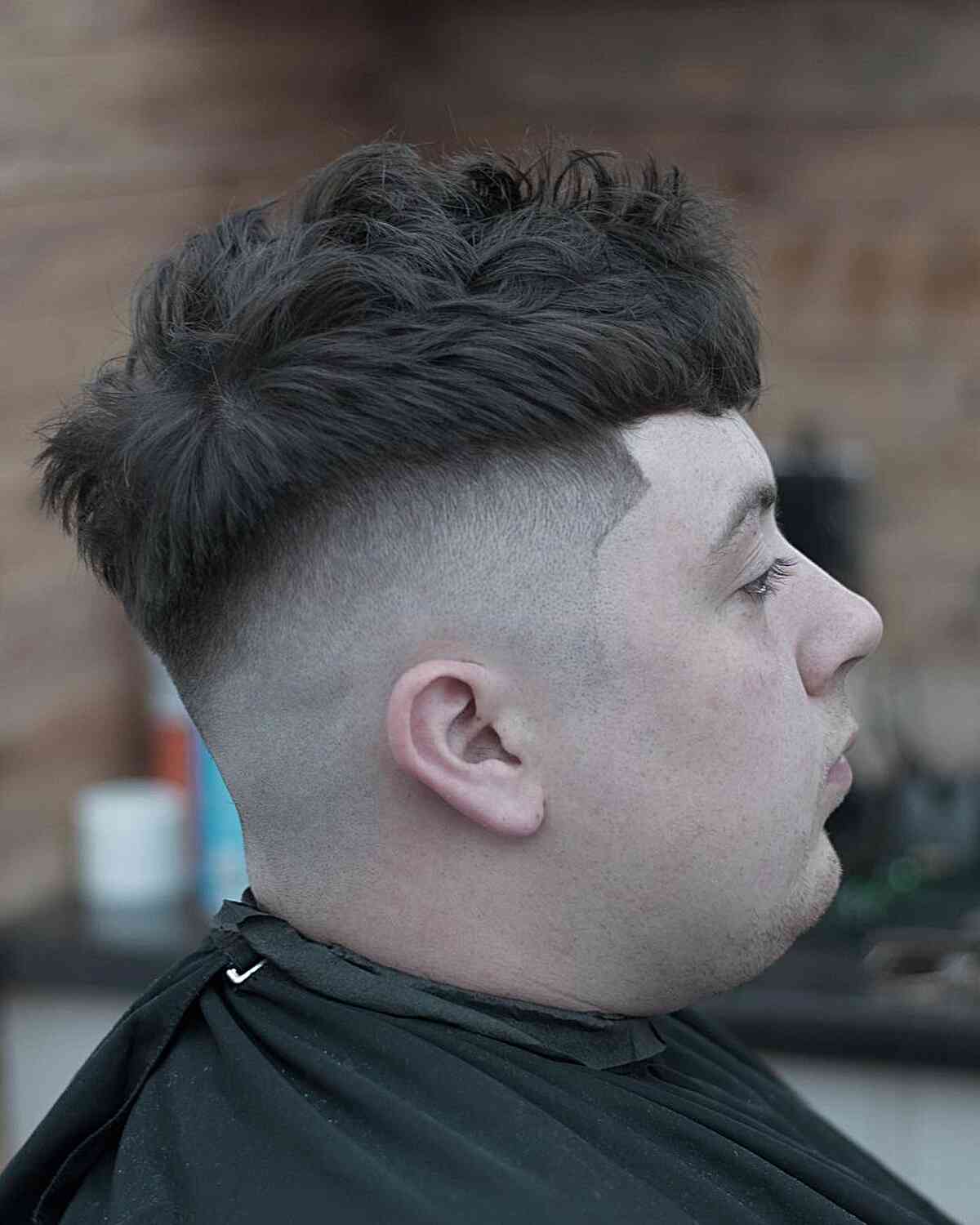 Textured short top with a blunt fringe and low bald fade.