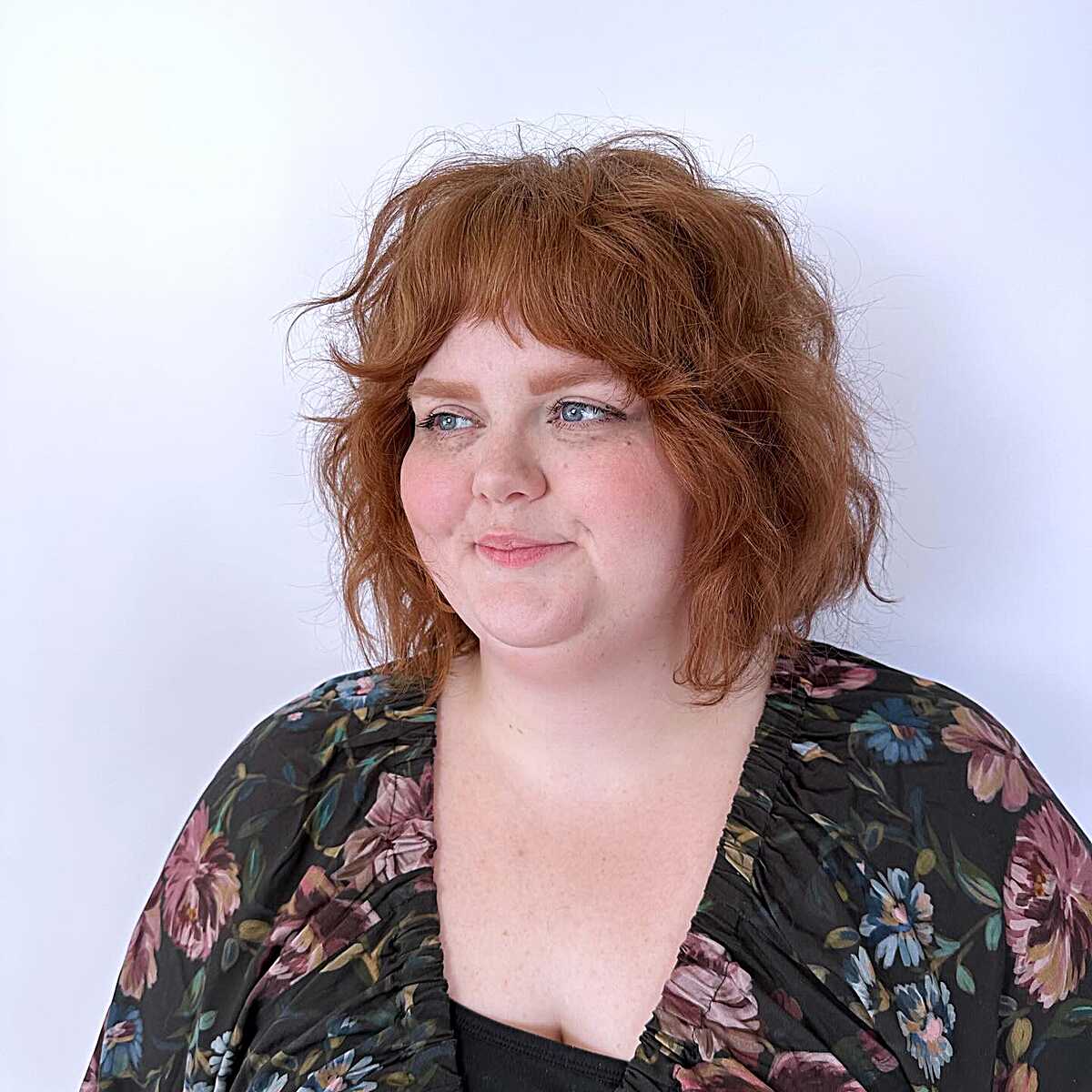 Copper wavy bob with full bangs and flipped ends