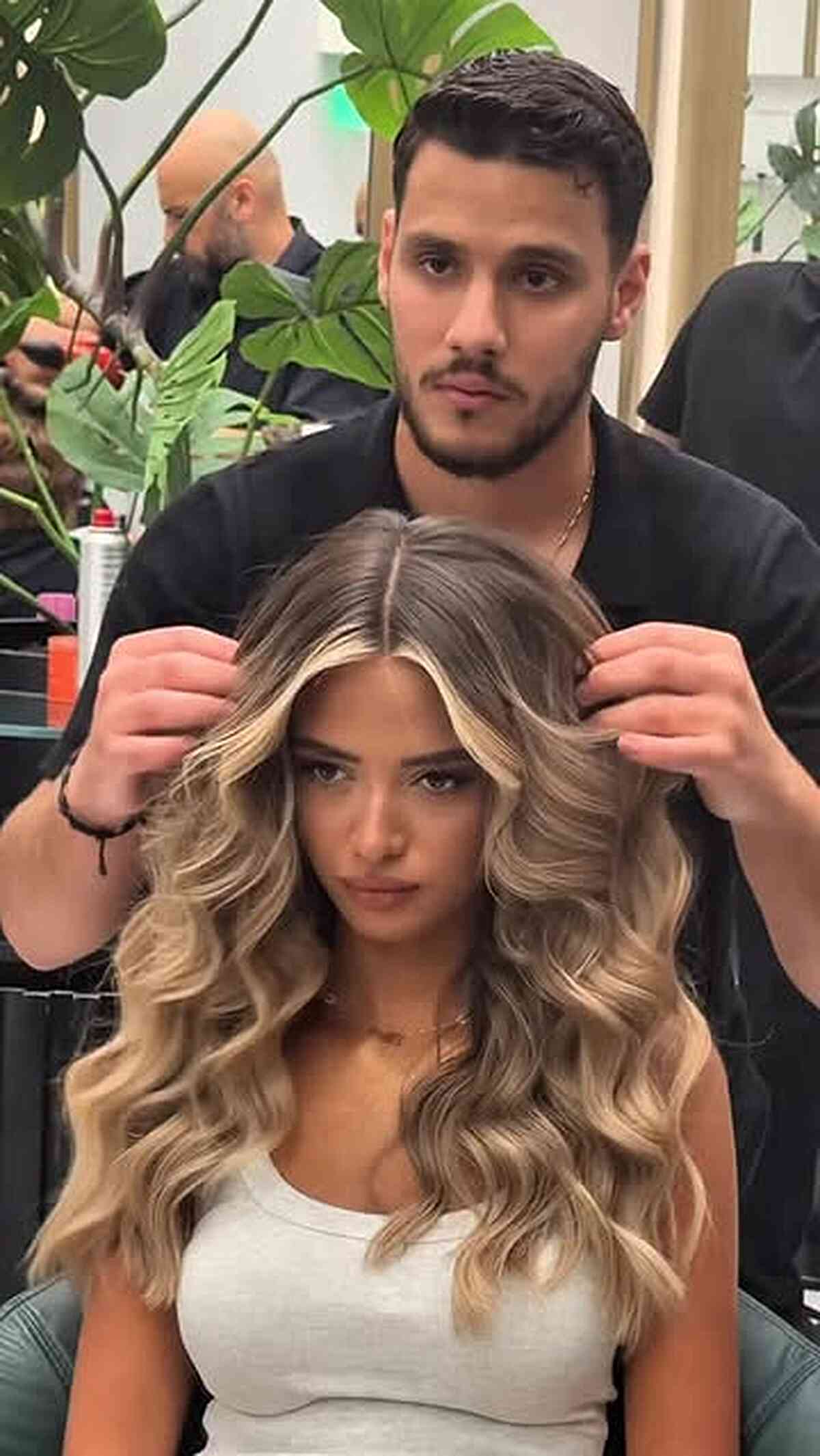 Long blonde waves with a center part and dimensional color.
