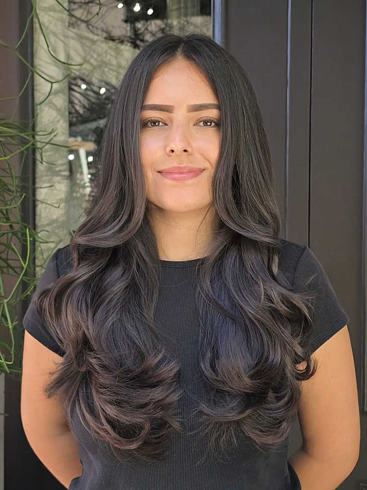 Long dark brunette hair with soft waves and voluminous layers.