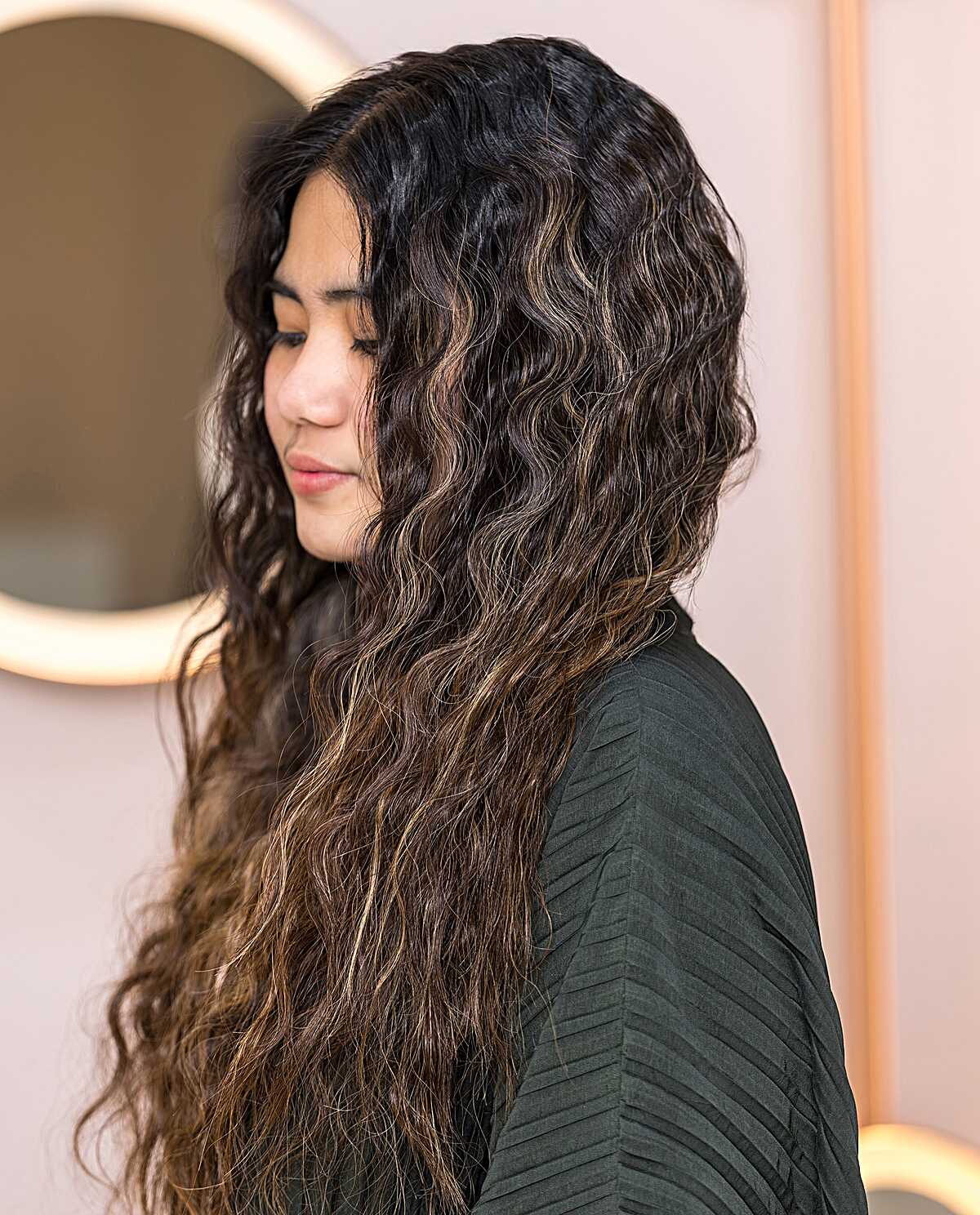 Very long dark wavy-curly hair with subtle highlights.