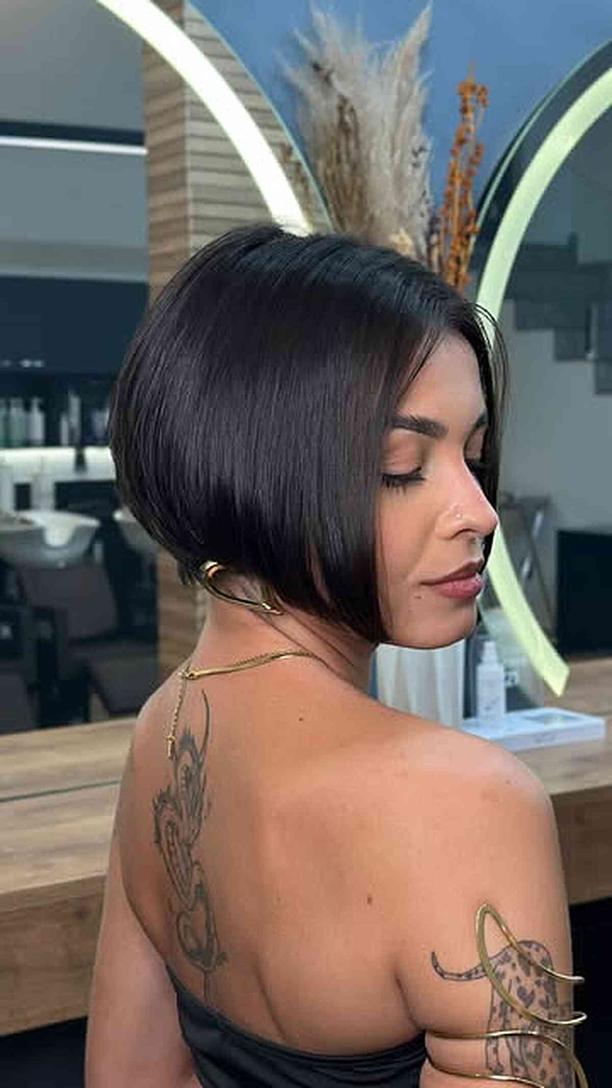 Dark sleek angled bob with a glossy finish and side part.