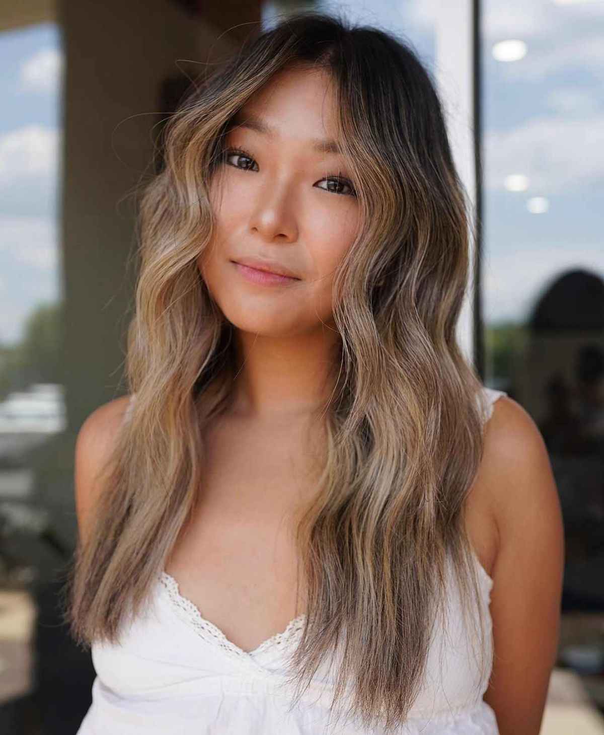 Long bronde hair with soft waves and airy lighter ends.